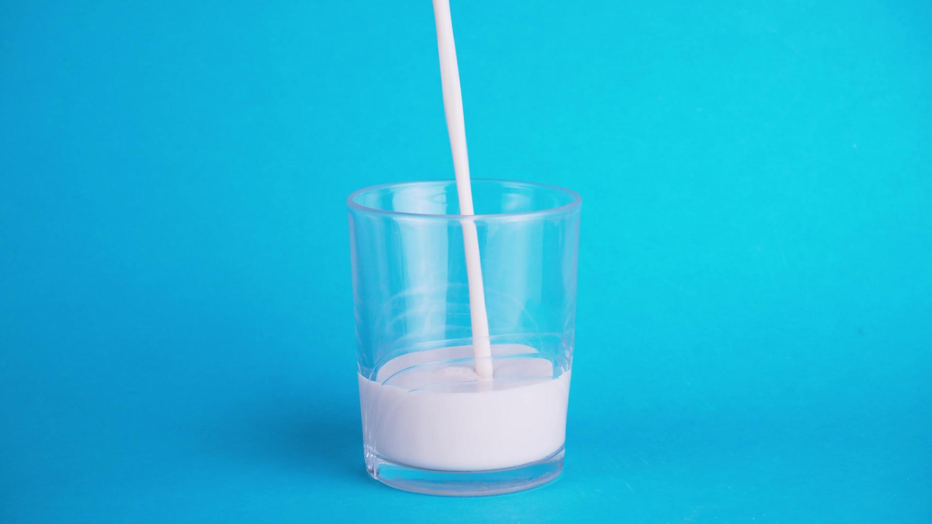 流行背景的概念是在蓝色背景上填充一杯牛奶和富含钙视频的预览图