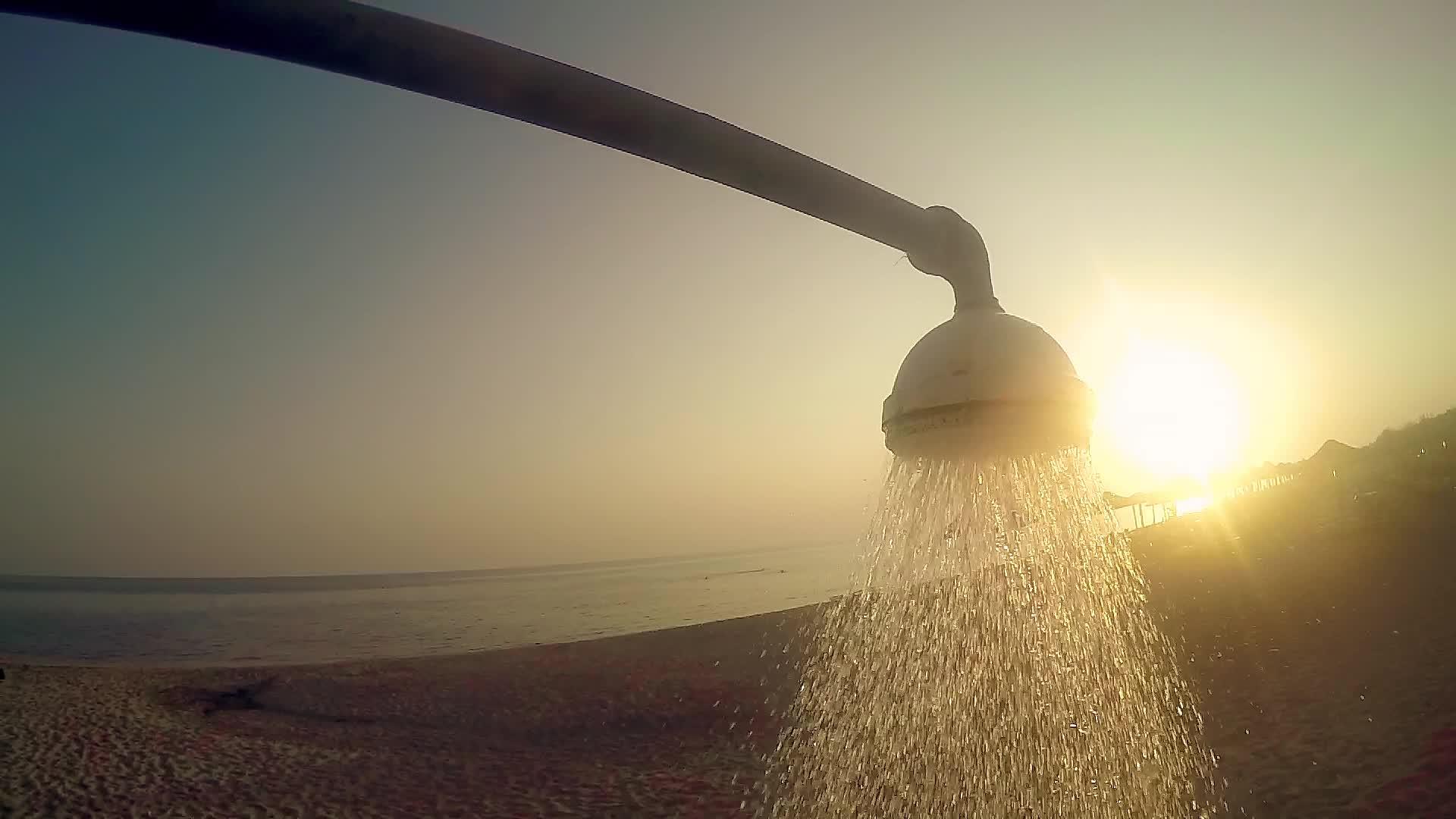 海滩淋浴水在日落时在海中缓慢流动视频的预览图