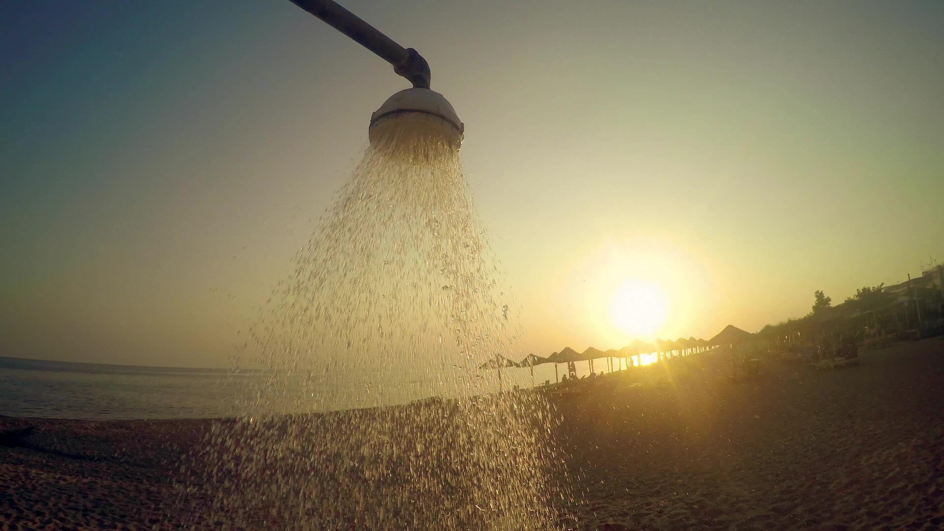 沙滩头淋浴用自来水对抗日落和夏季太阳的概念视频的预览图