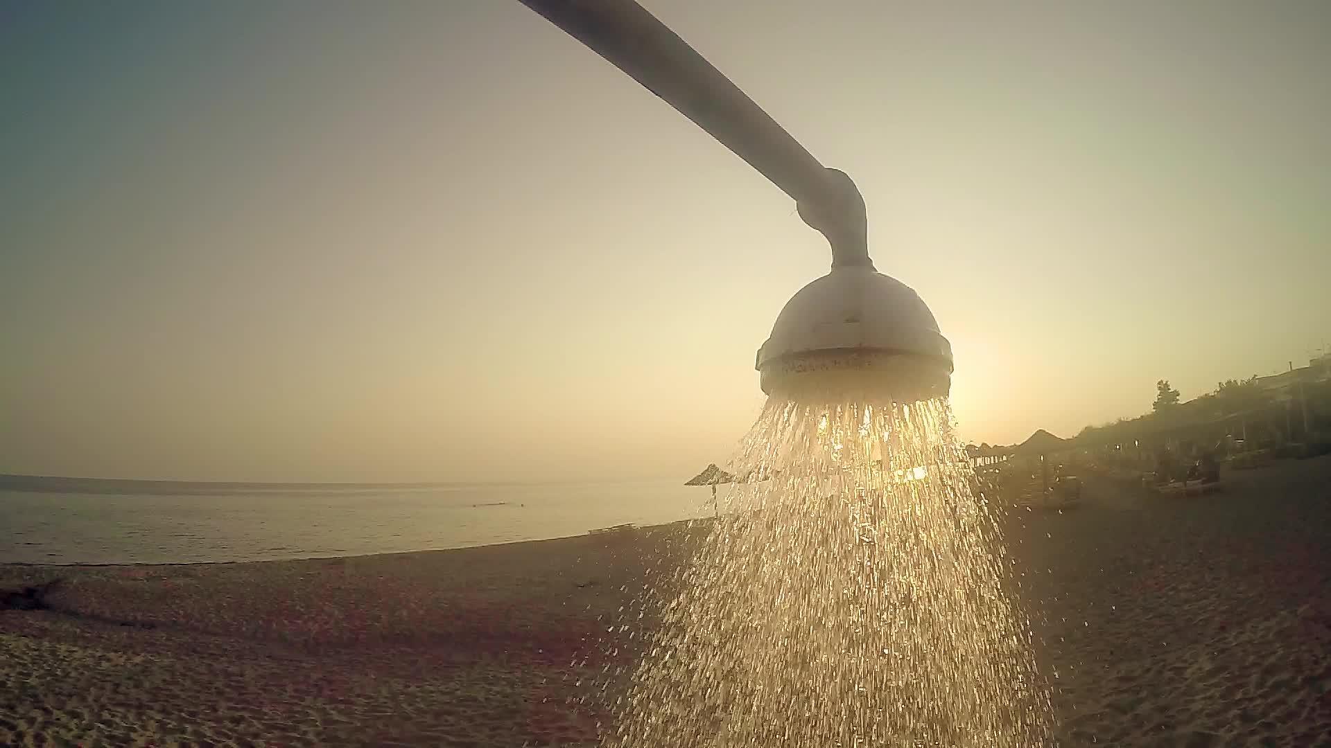 夏季概念慢动作沙滩头浴用自来水对抗日落太阳视频的预览图