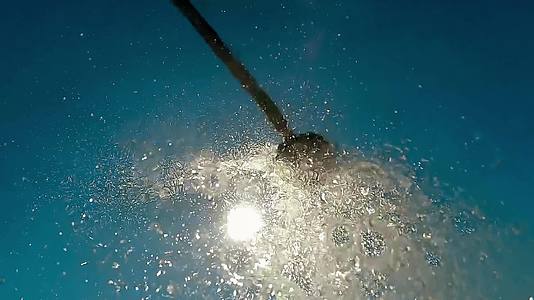沙滩淋浴水滴落在摄像机上慢慢地向蓝天移动视频的预览图