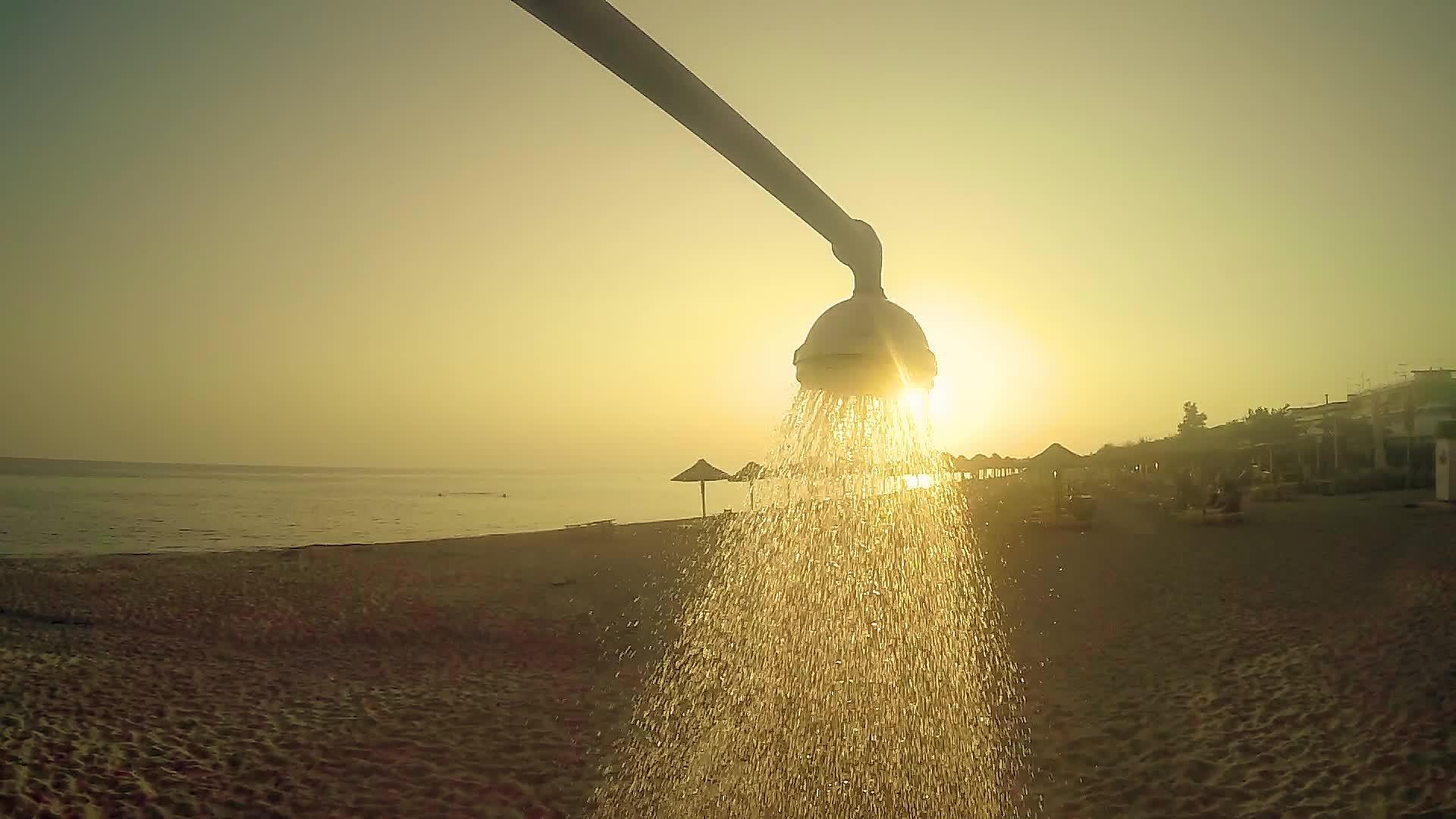 夏天和夏天海滩淋浴水在夕阳下慢慢倾注运动视频的预览图