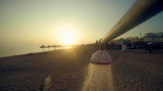 夏天和夏天海滩淋浴水倾注在夕阳下视频的预览图