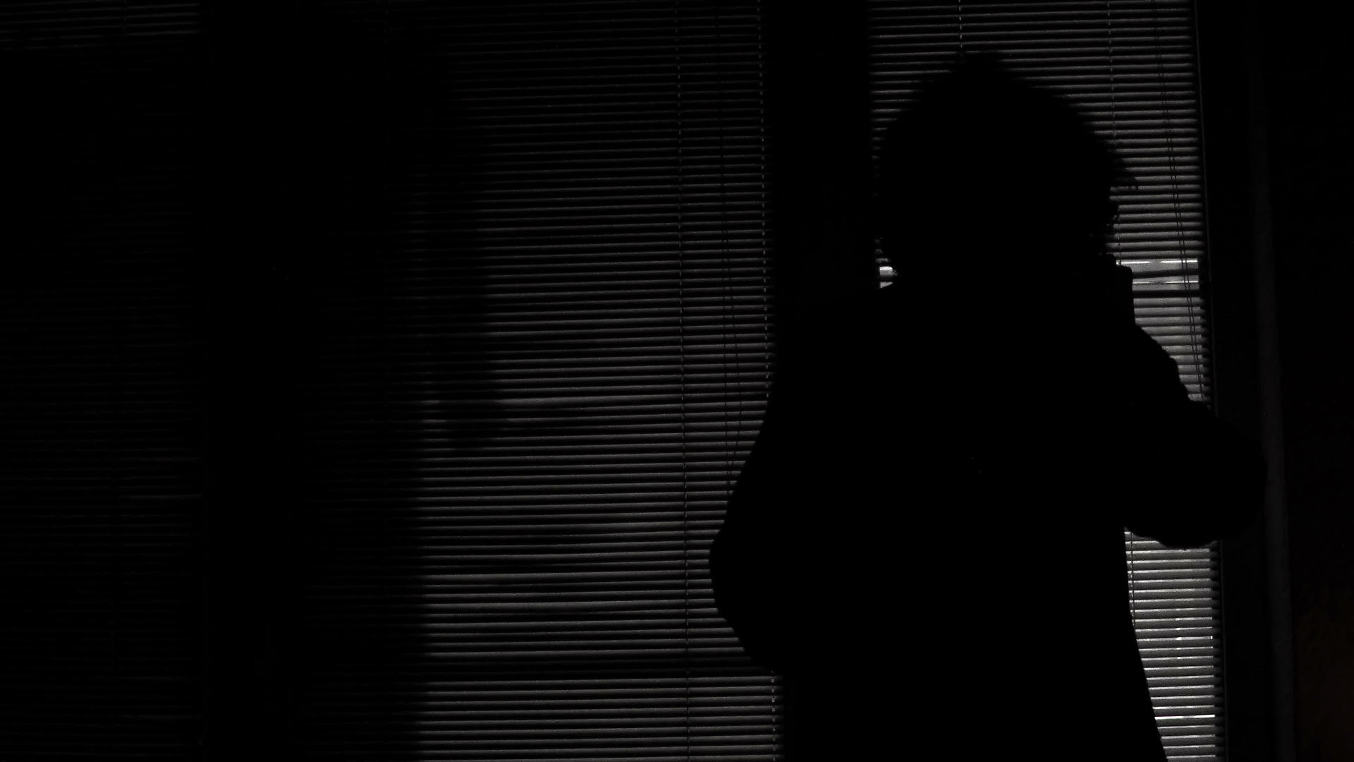 一个没有睡眠的孤独女人在晚上看着室外的灯光抬头看着窗帘视频的预览图