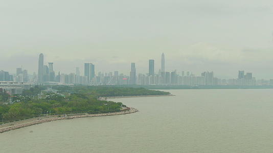 在深圳湾和城市风景中无人驾驶飞机在空中向上飞行视频的预览图