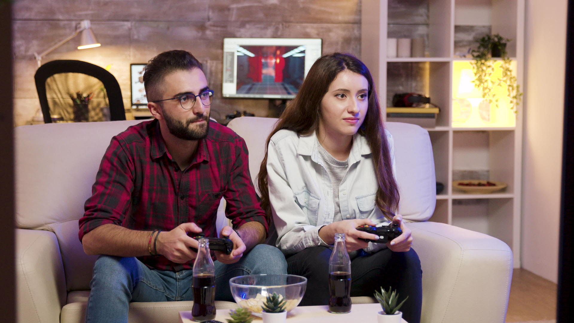 快乐的年轻情侣坐在一对情侣上玩电子游戏视频的预览图