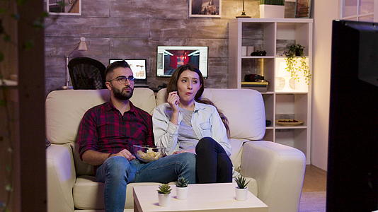 看电影的时候情侣们坐在沙发上吃薯片视频的预览图