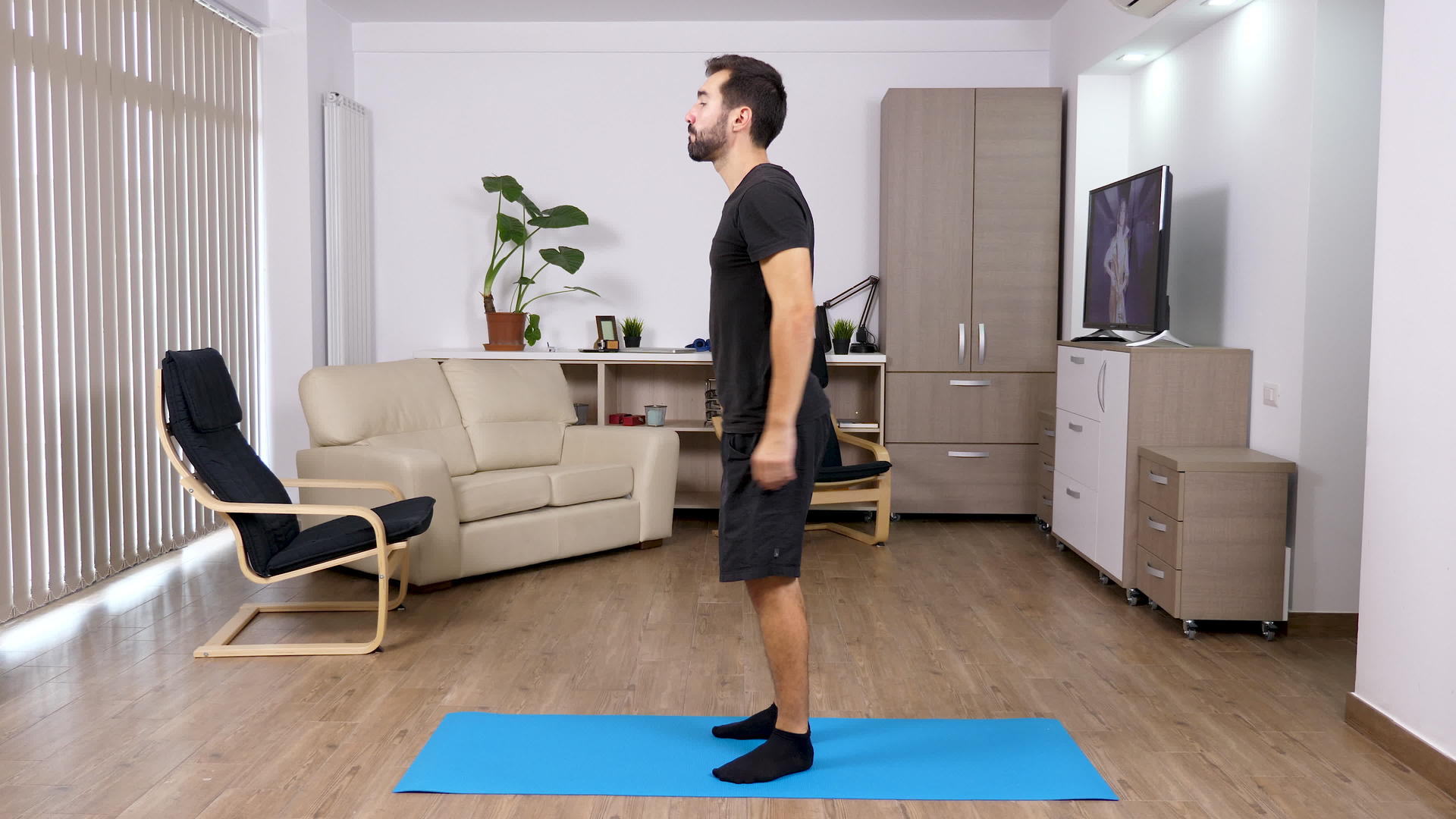 在家锻炼-强壮的男人蹲在客厅里视频的预览图