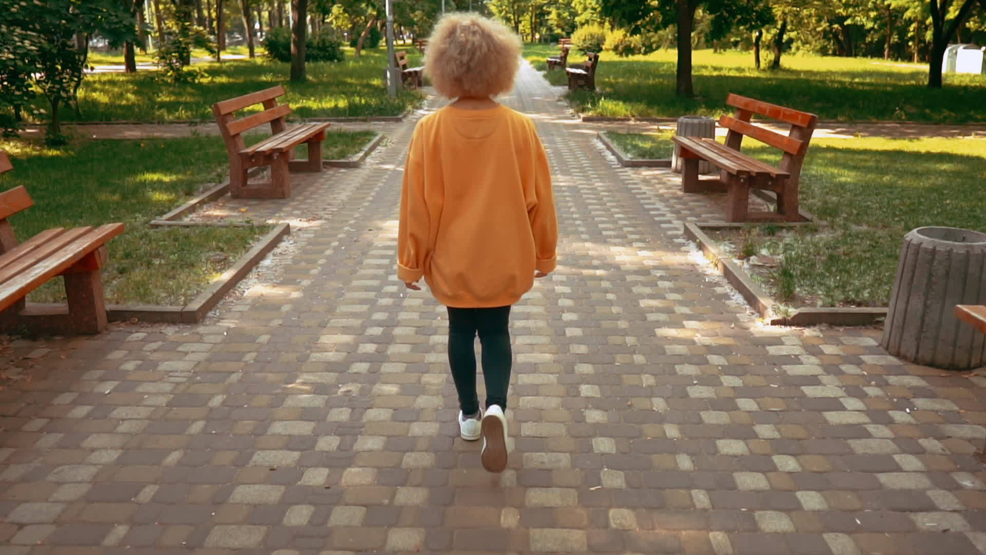 金发女子在城市公园散步视频的预览图