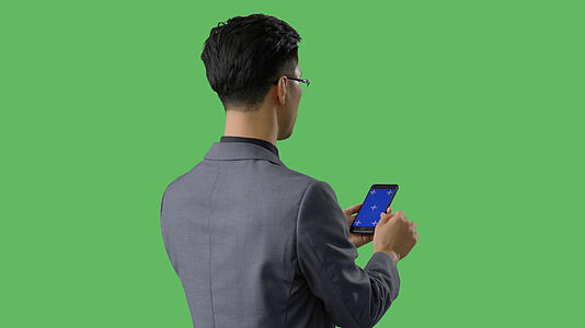 4k绿幕合成抠像穿西装使用蓝幕手机背影形象视频的预览图