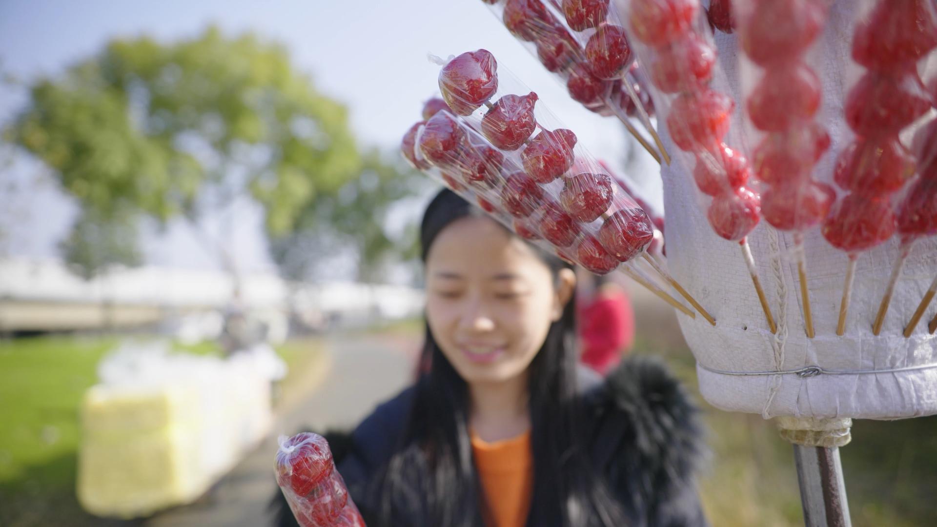 4K实拍女孩取冰糖葫芦视频素材视频的预览图