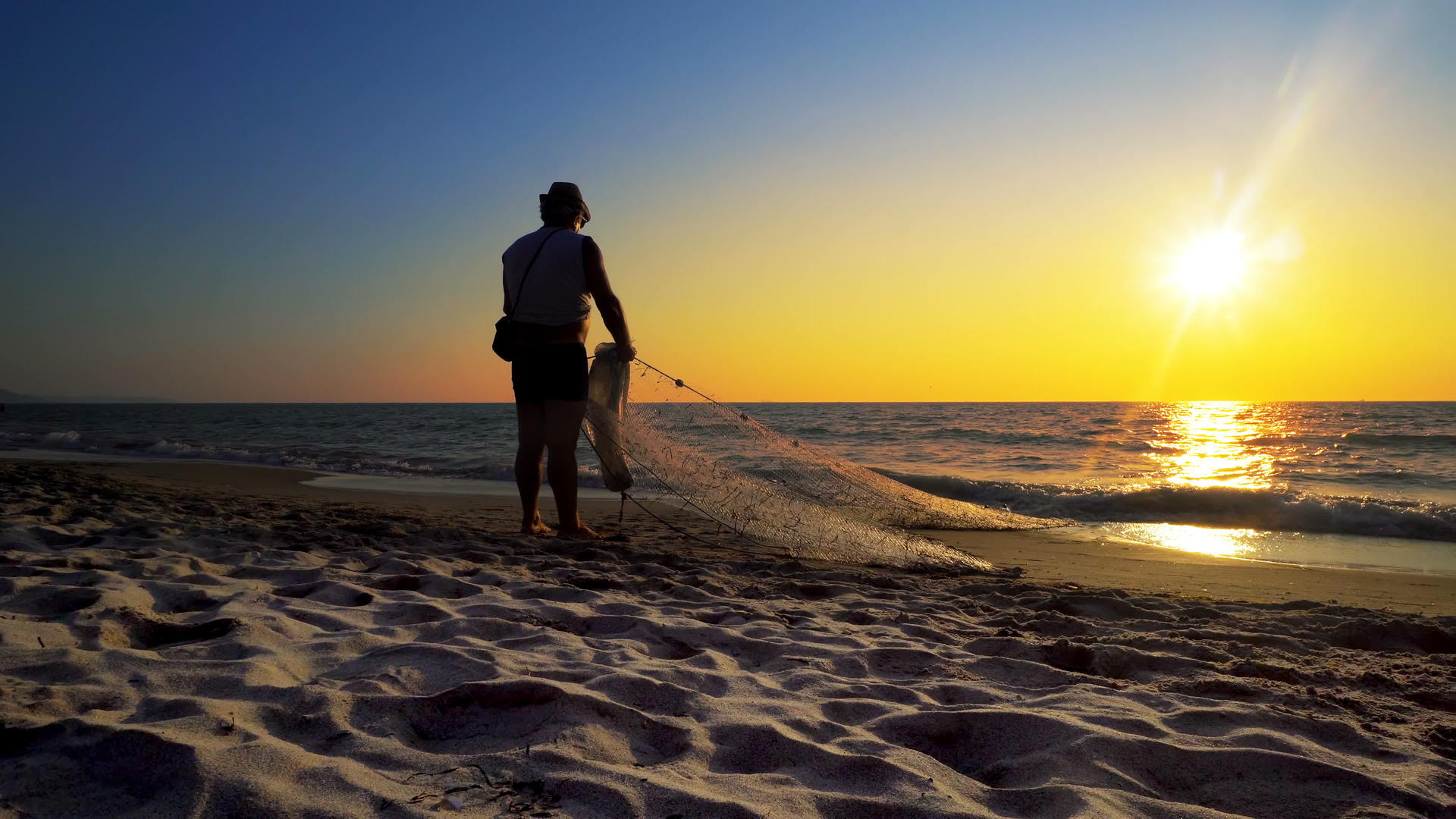 日落时传统渔民在海边的渔网中捕捉轮光和影视频的预览图