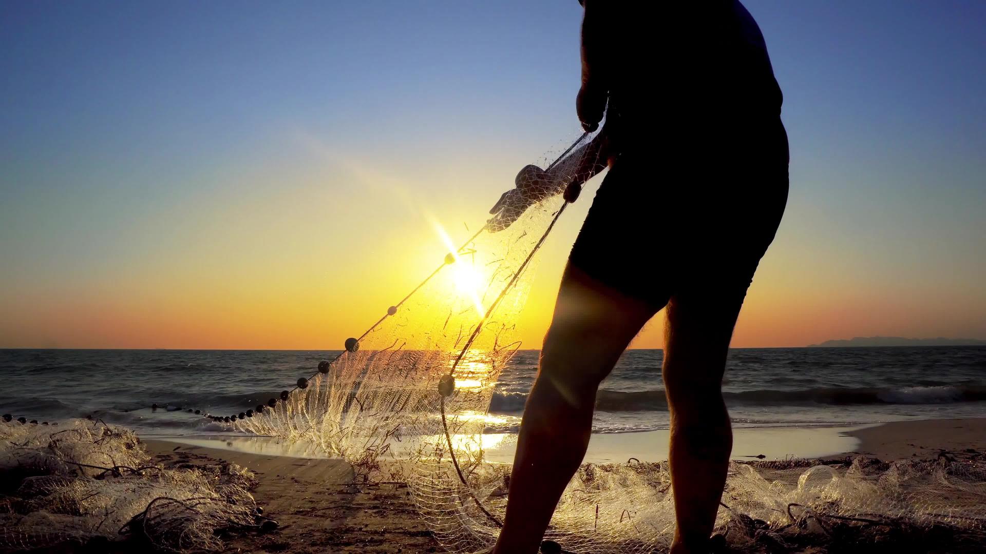 沿海海岸的渔民在海边日落时用手拉网视频的预览图