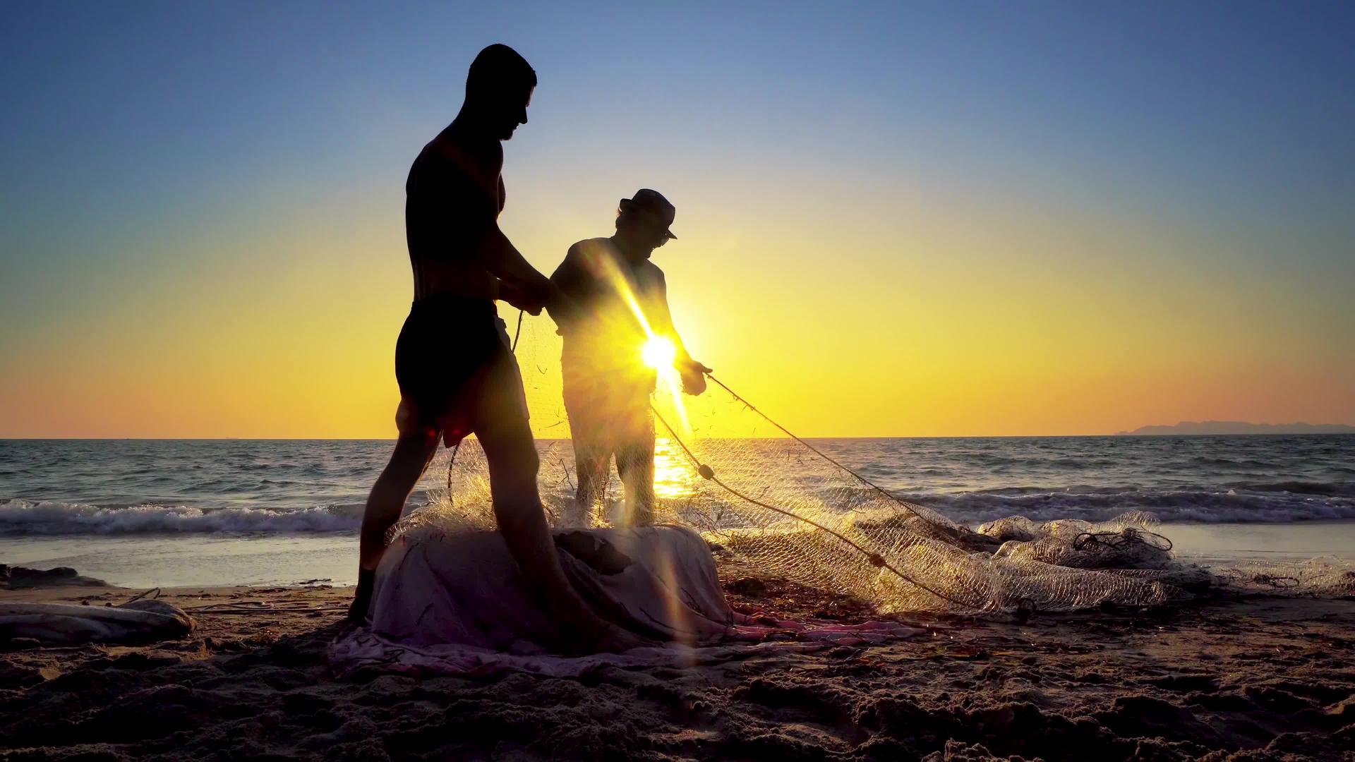 日落时传统渔民在海洋海岸拉网捕鱼视频的预览图