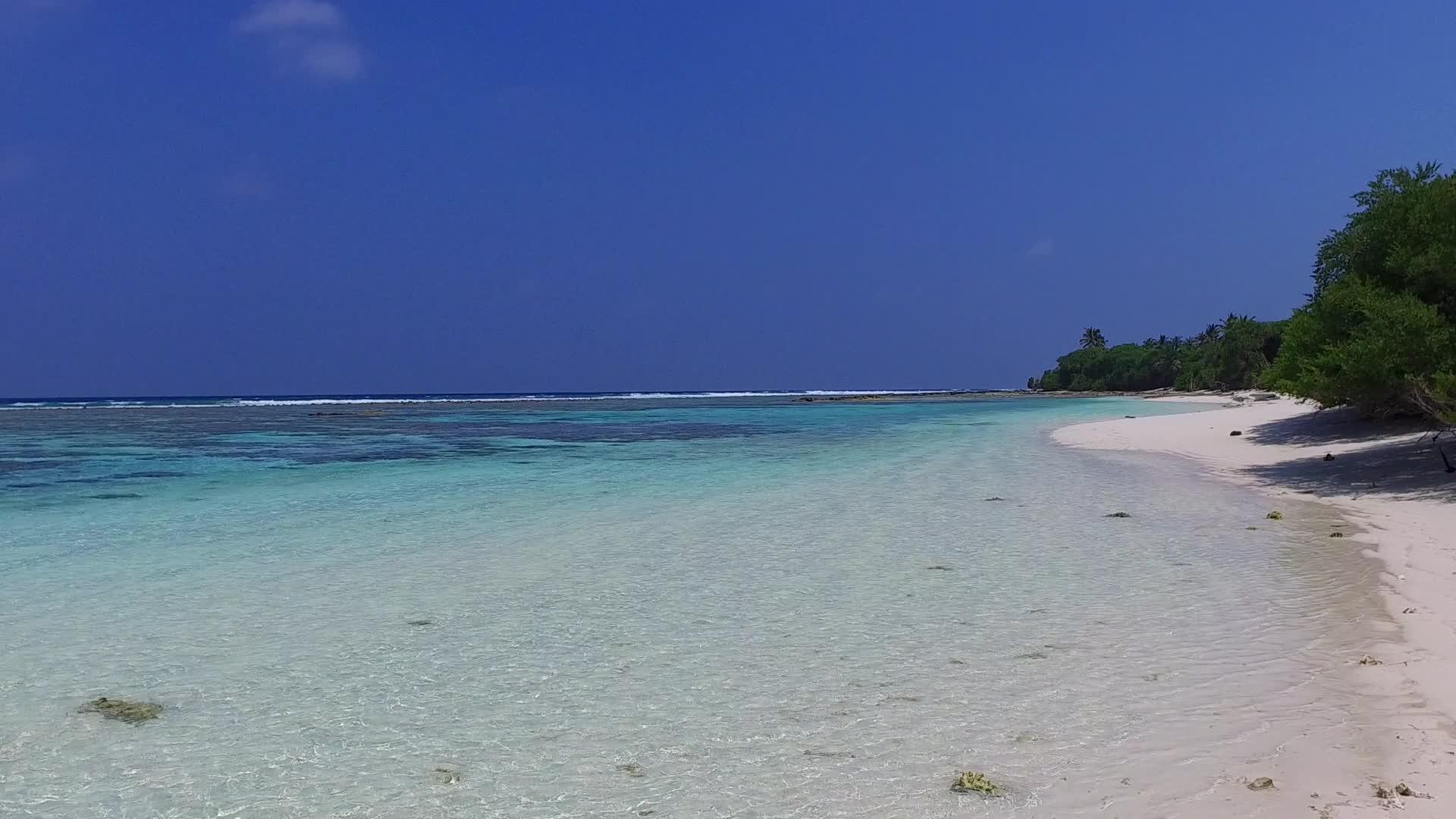 以蓝绿色的大海和靠近海浪的浅沙背景为例探索奇怪的海岸海滩视频的预览图