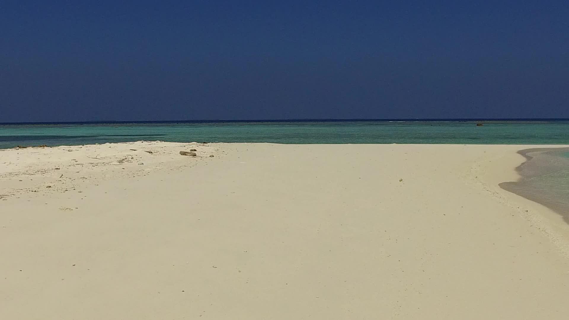 蓝色环礁阳光下有白色沙底蓝色礁的白色沙底背景视频的预览图