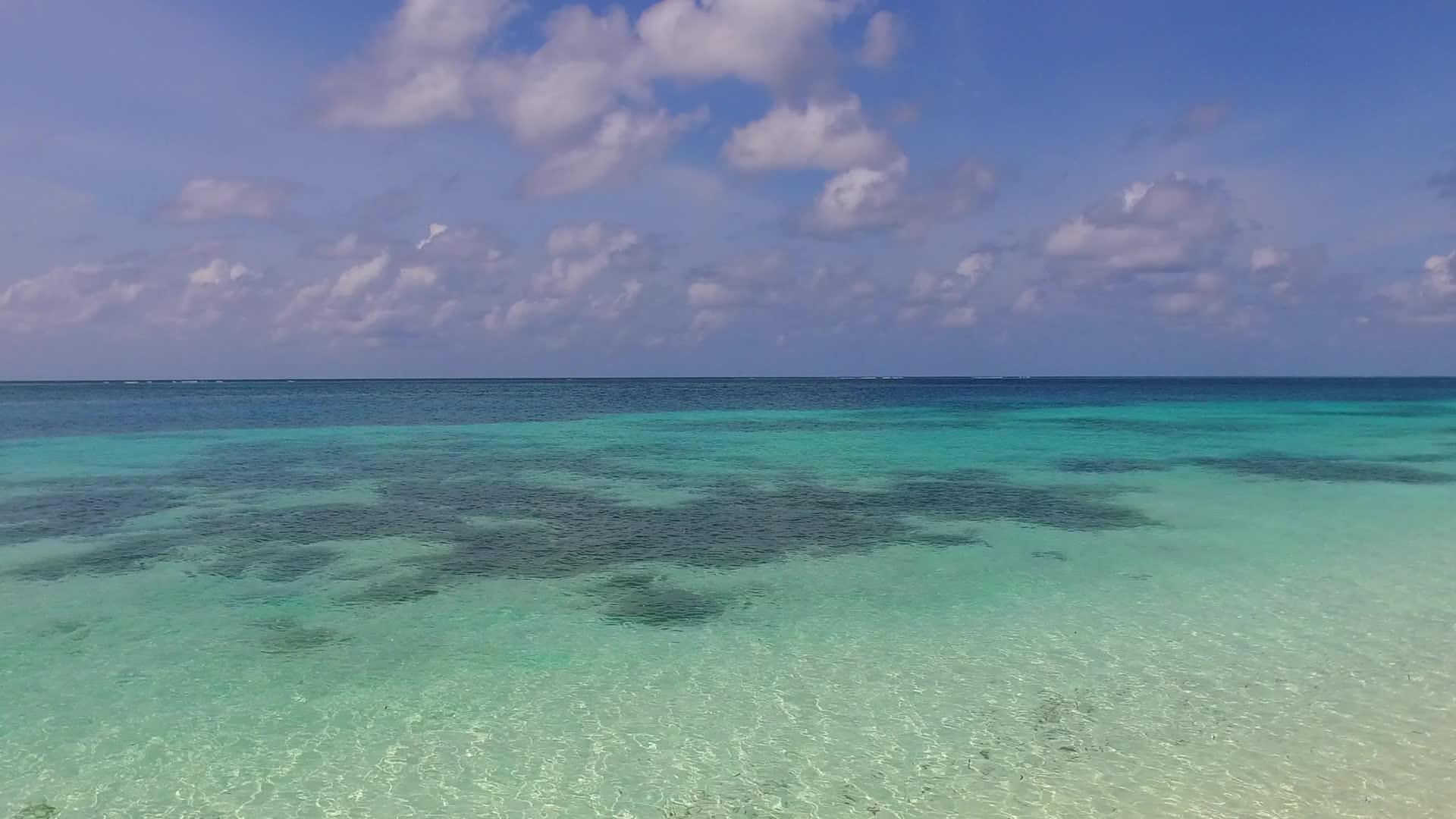 蓝色的环礁湖和接近冲浪的白色沙底背景是完美的海湾海滩假日视频的预览图