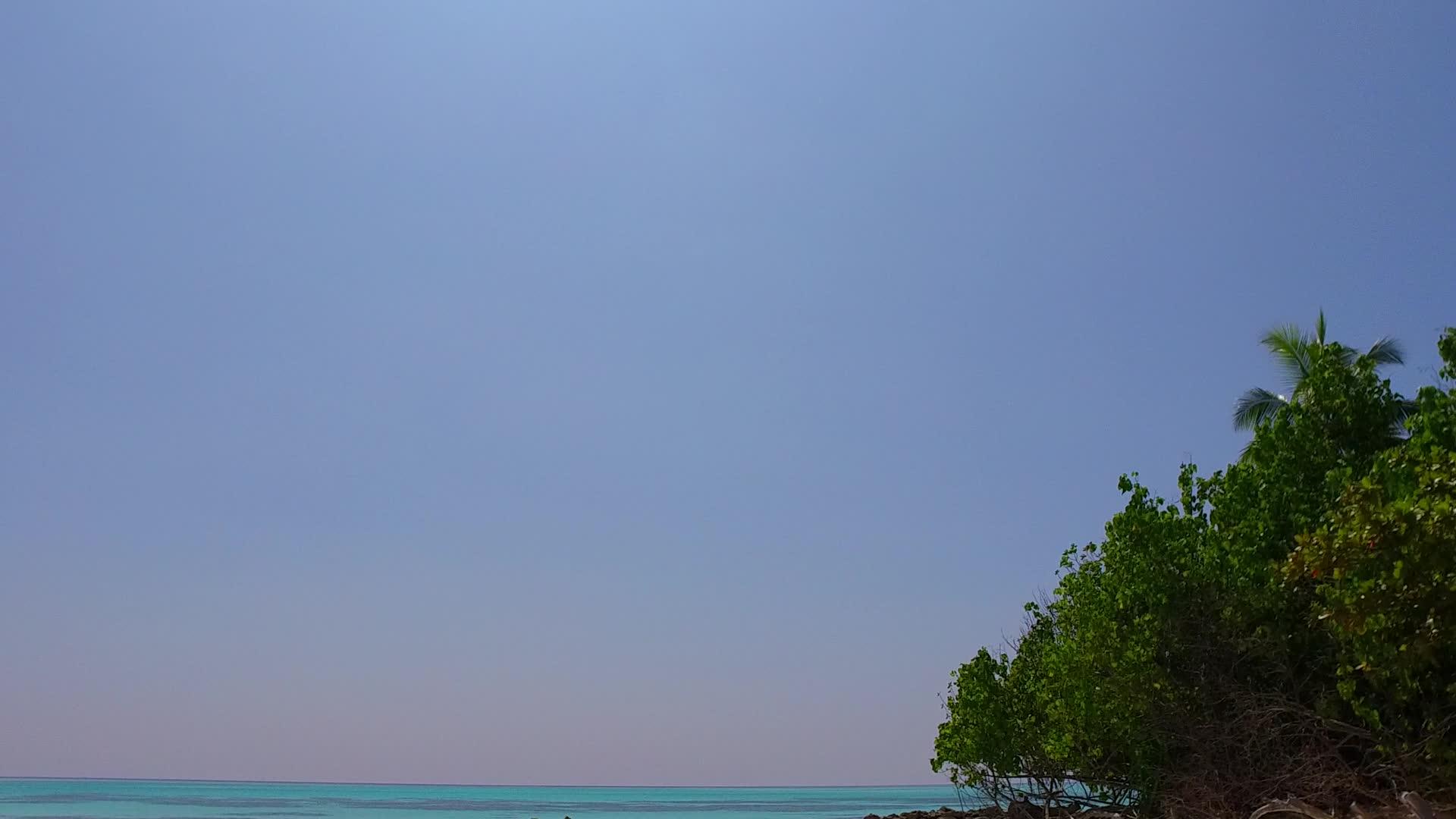 在温暖的天空中享受蓝色的海水和度假村附近干净的沙质背景视频的预览图