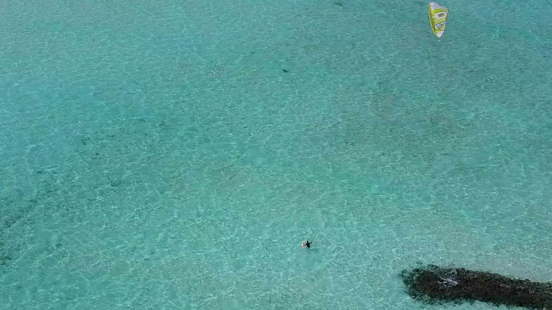 浅环礁湖以明亮的沙滩为背景在度假胜地附近冒着天堂岛海滩视频的预览图