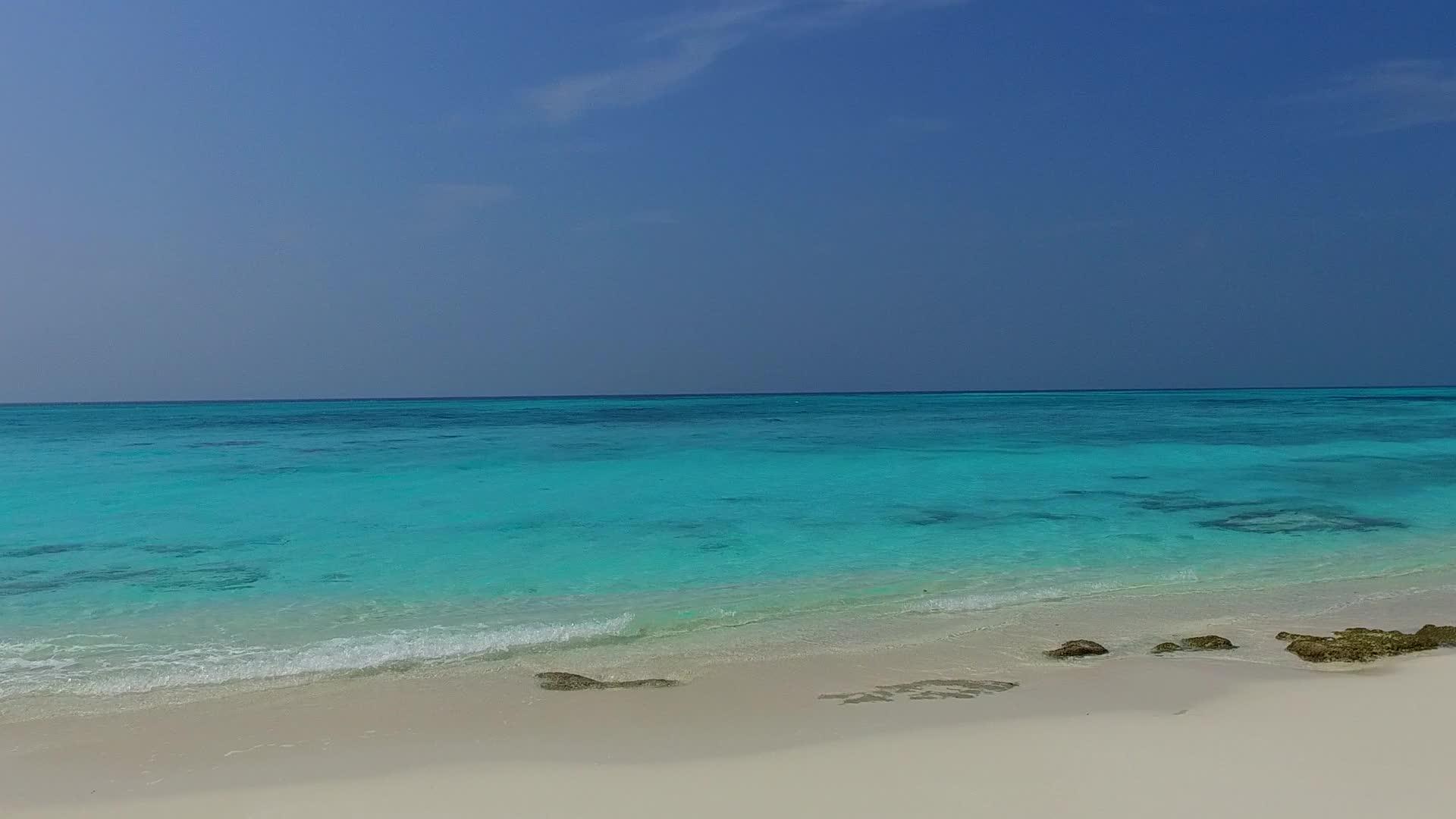 通过透明的环礁湖和接近冲浪的白色海滩背景视频的预览图