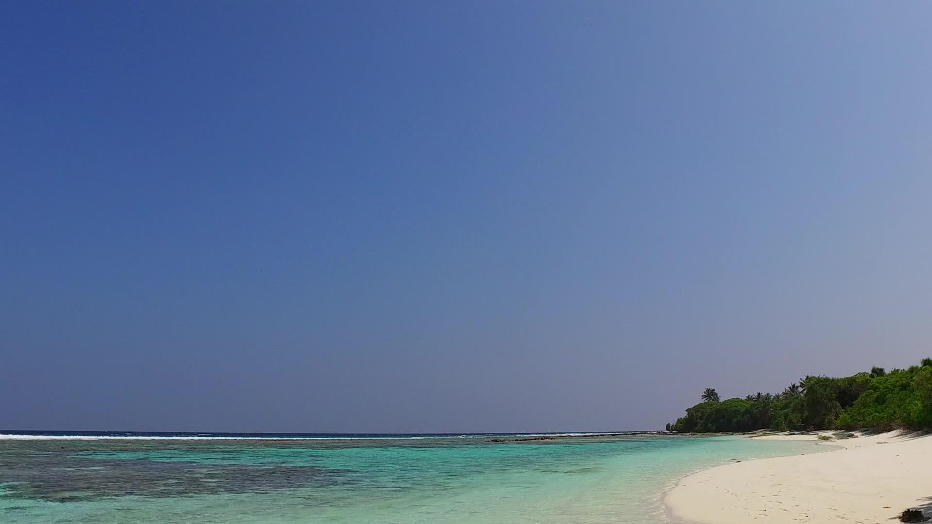 沙巴附近的蓝色水礁湖和白色沙滩背景的白色沙滩落在阳光下视频的预览图