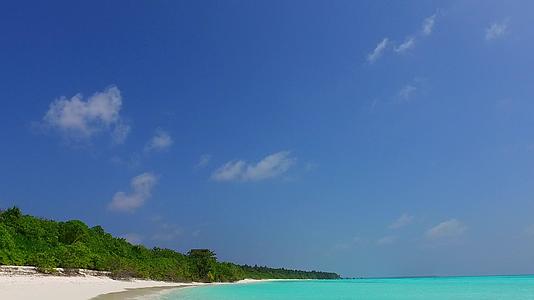 在珊瑚礁附近的蓝海和白沙的背景下海滩度假是一个自然和开放的天堂视频的预览图