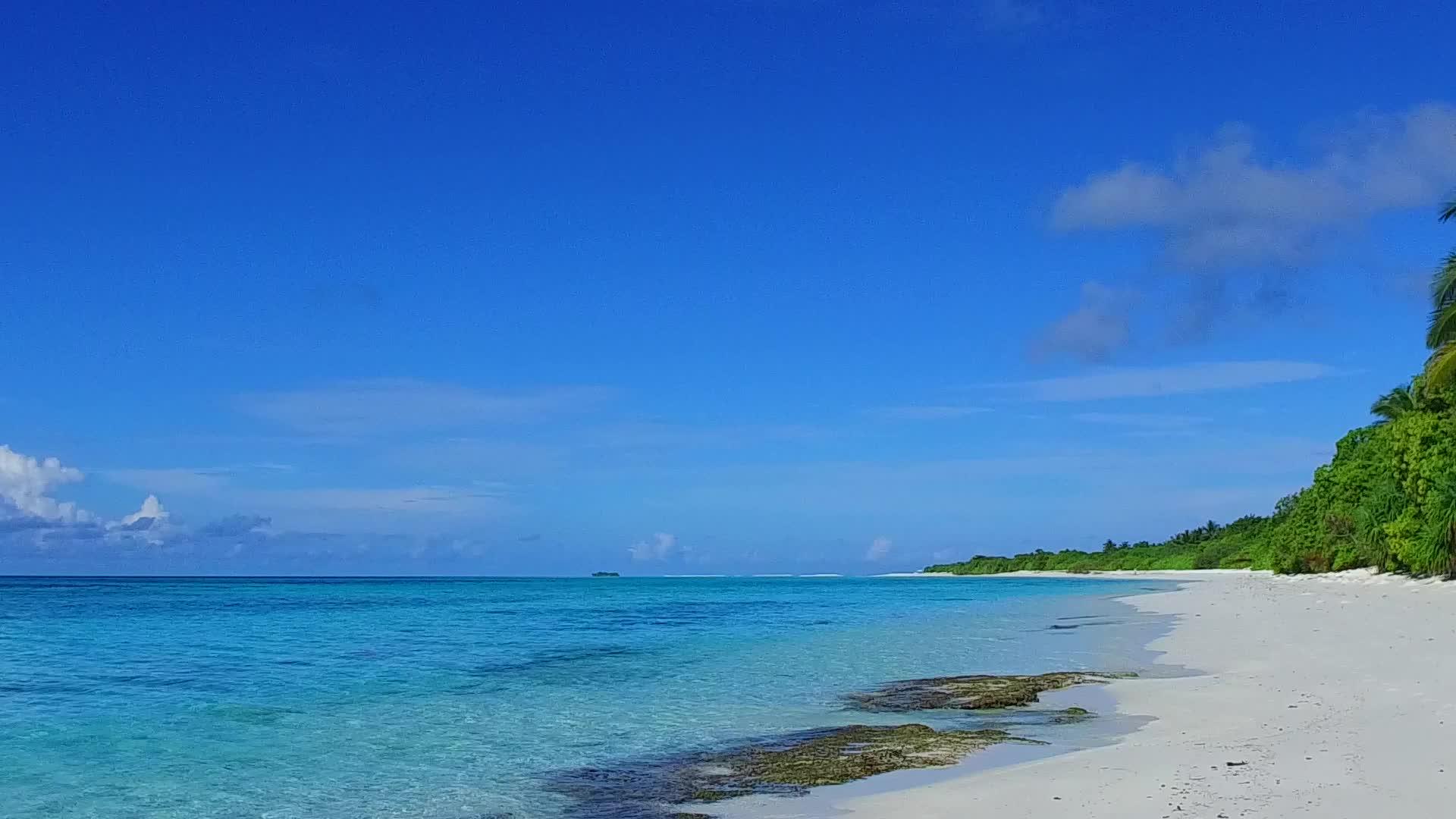 以蓝水和白色沙滩为背景在海浪附近进行晴朗的旅游视频的预览图