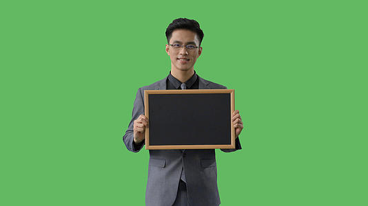 4k绿幕合成抠像戴眼镜的商务男性展示黑板形象视频的预览图