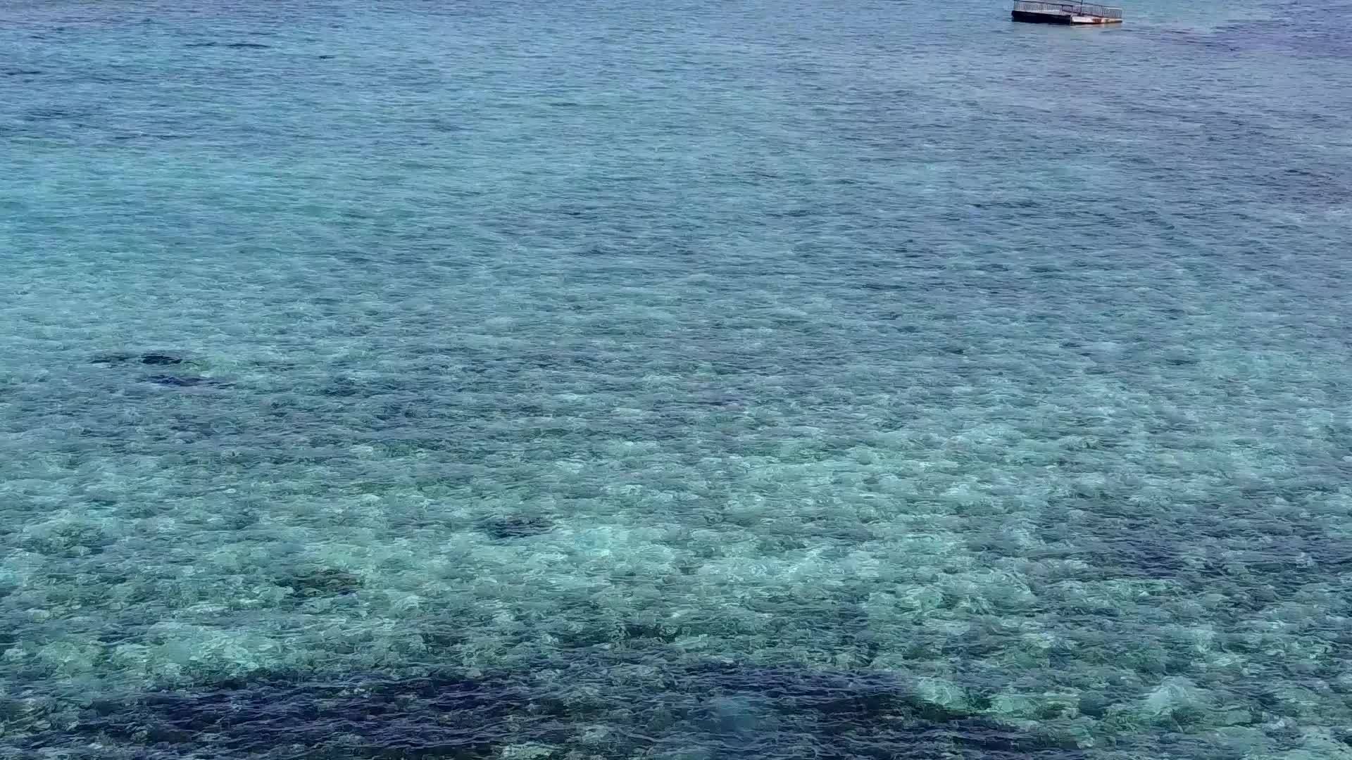 通过透明的环礁湖冲浪附近有一个干净的沙底背景视频的预览图