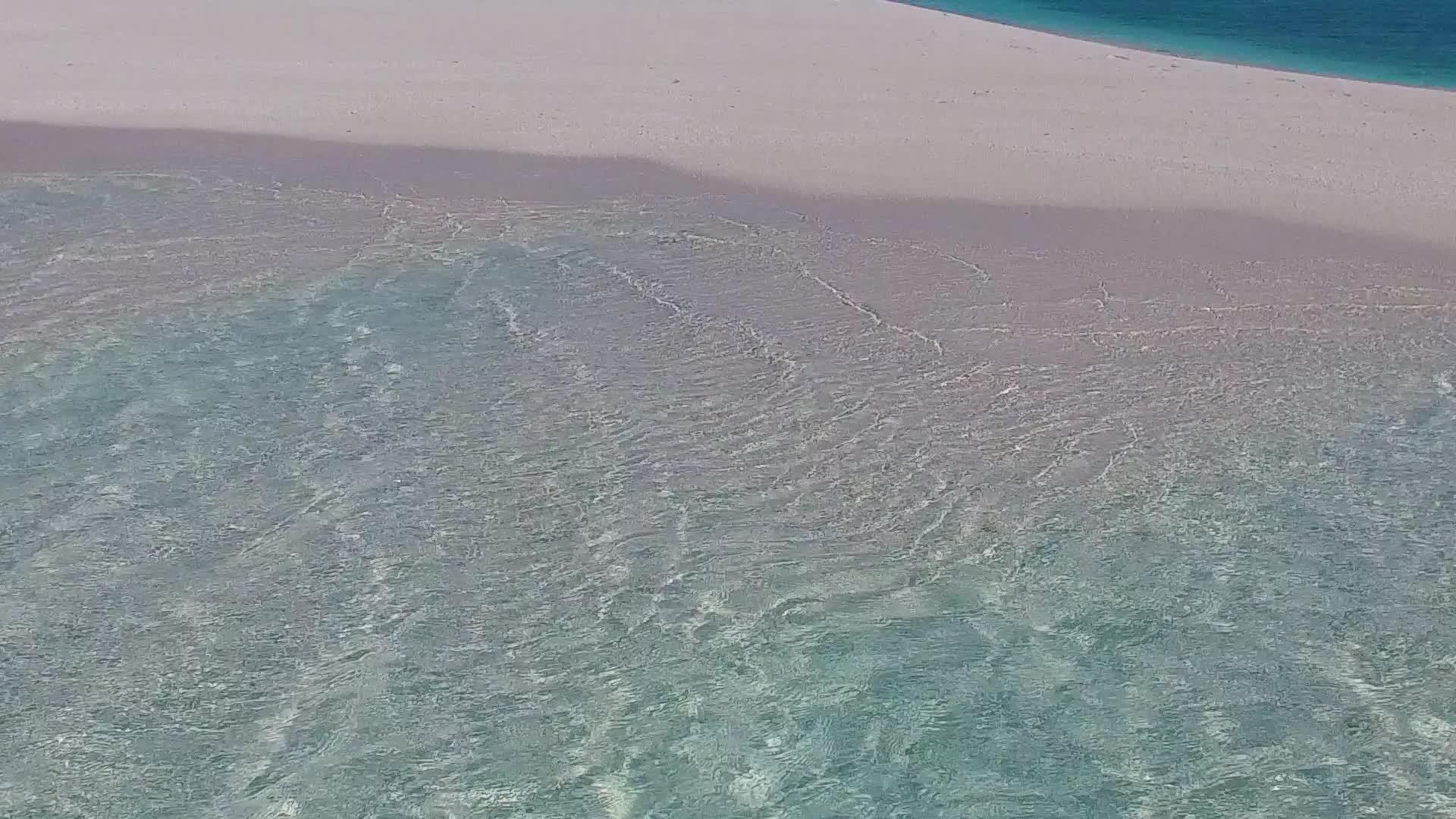 在珊瑚礁附近有白色沙子的蓝色水中用蓝色的水打破了海滩视频的预览图