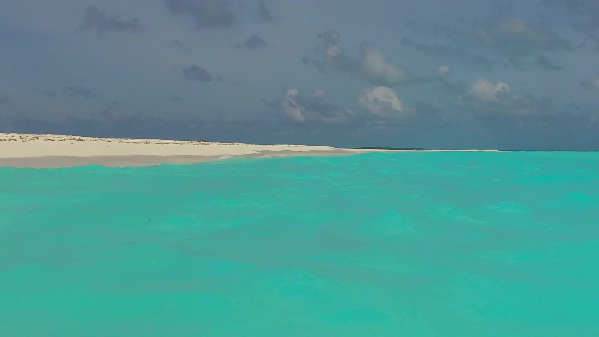 海浪附近的蓝色水礁湖和白色沙滩背景的空泥沙度假胜地视频的预览图