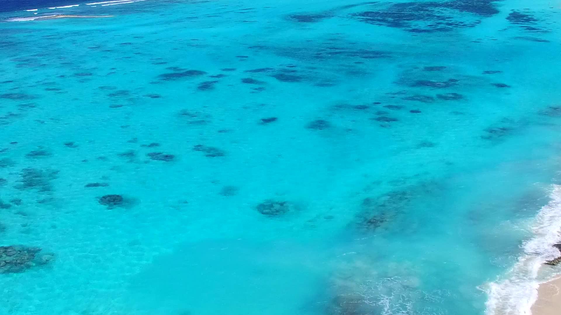 沙洲附近白色沙滩背景下的水蓝色海洋田园诗般的海滩海滩视频的预览图
