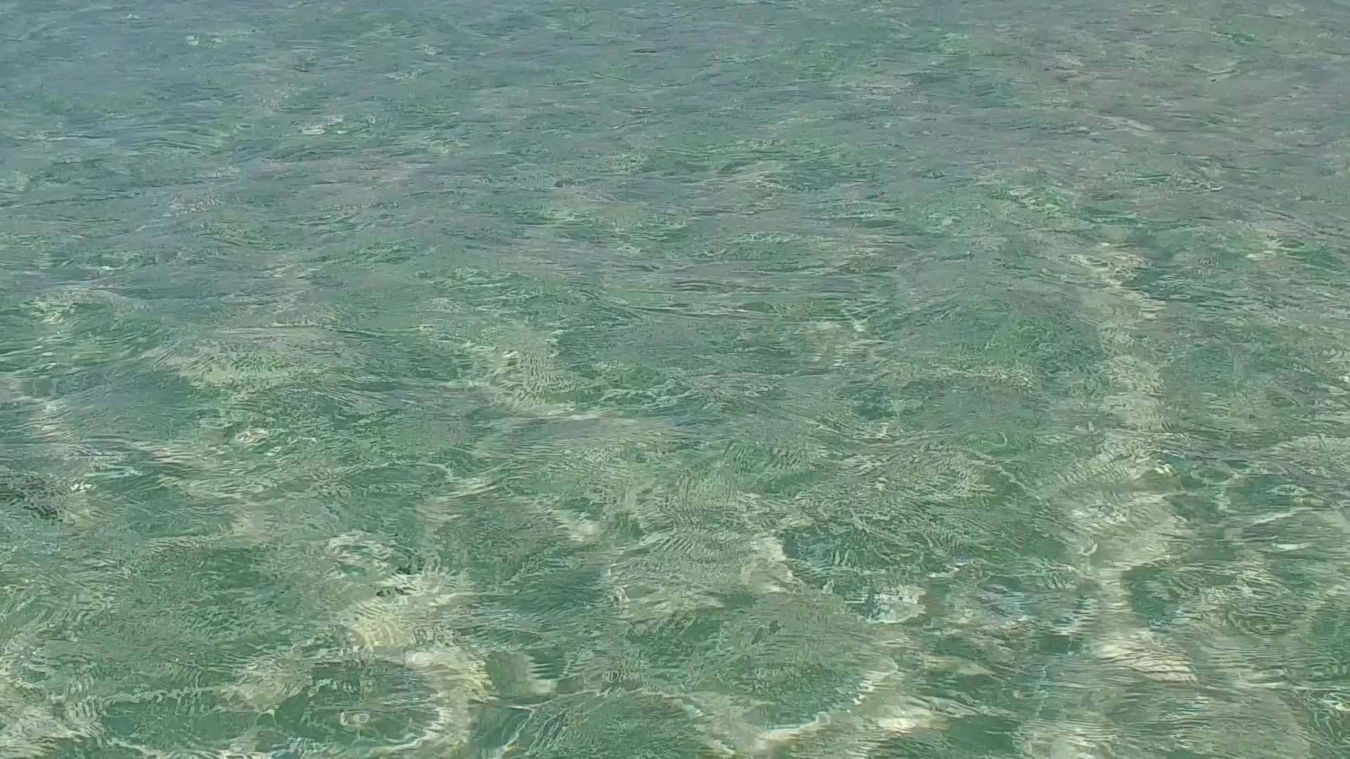 通过透明的水和靠近度假胜地的白色沙沙背景有一个豪华的海湾湾视频的预览图