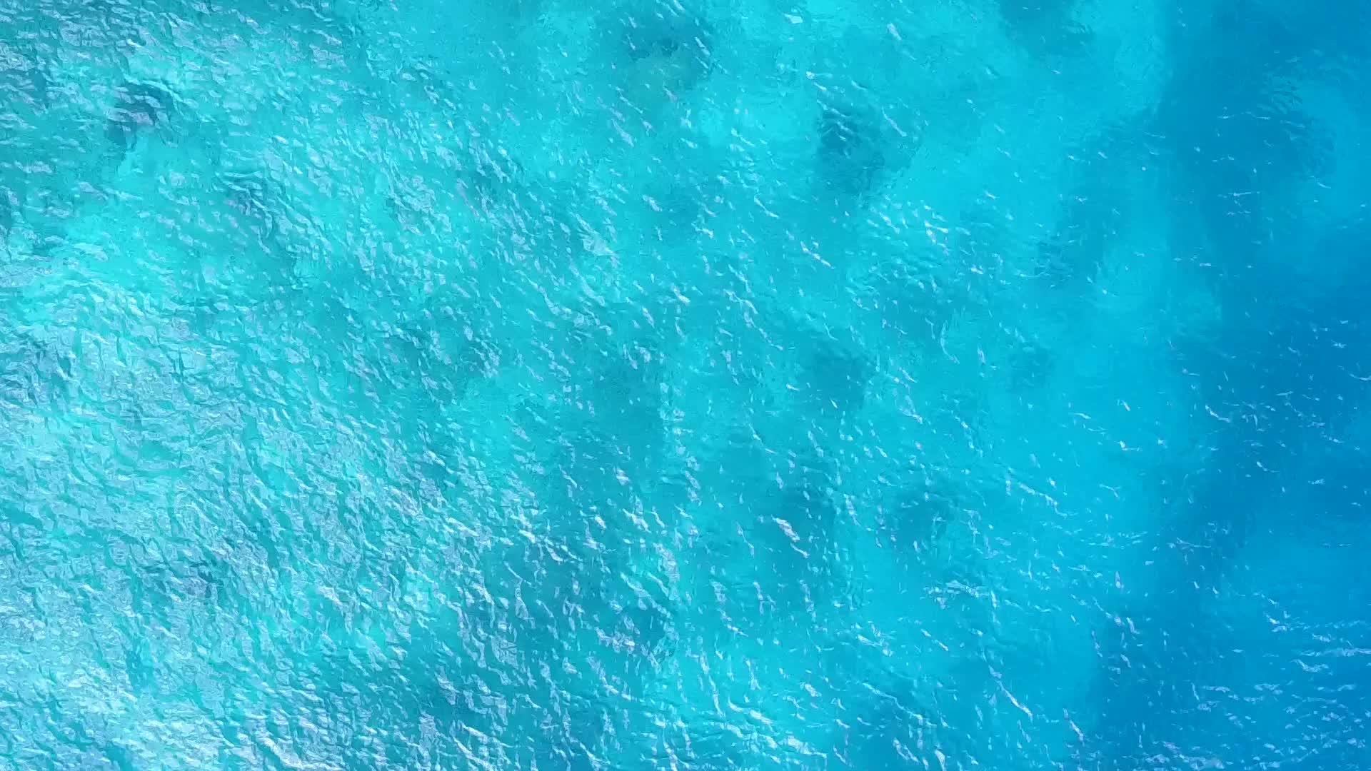 安静的海滨海滩在透明的水道上航行全夏清澈的沙滩底部靠近波浪视频的预览图