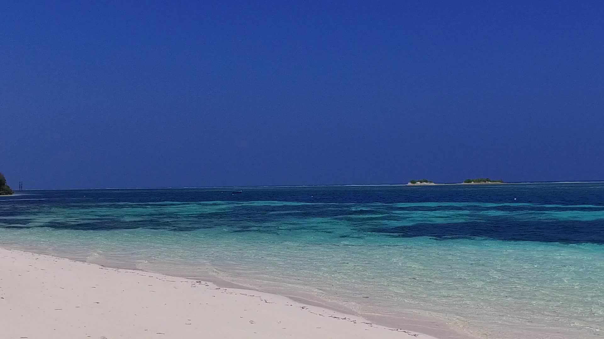 在沙洲附近的透明海洋中有明亮的沙质背景近距离欣赏和放松视频的预览图