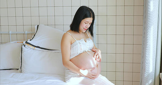 孕妇准妈妈抚摸怀孕的肚子和胎宝宝互动视频的预览图