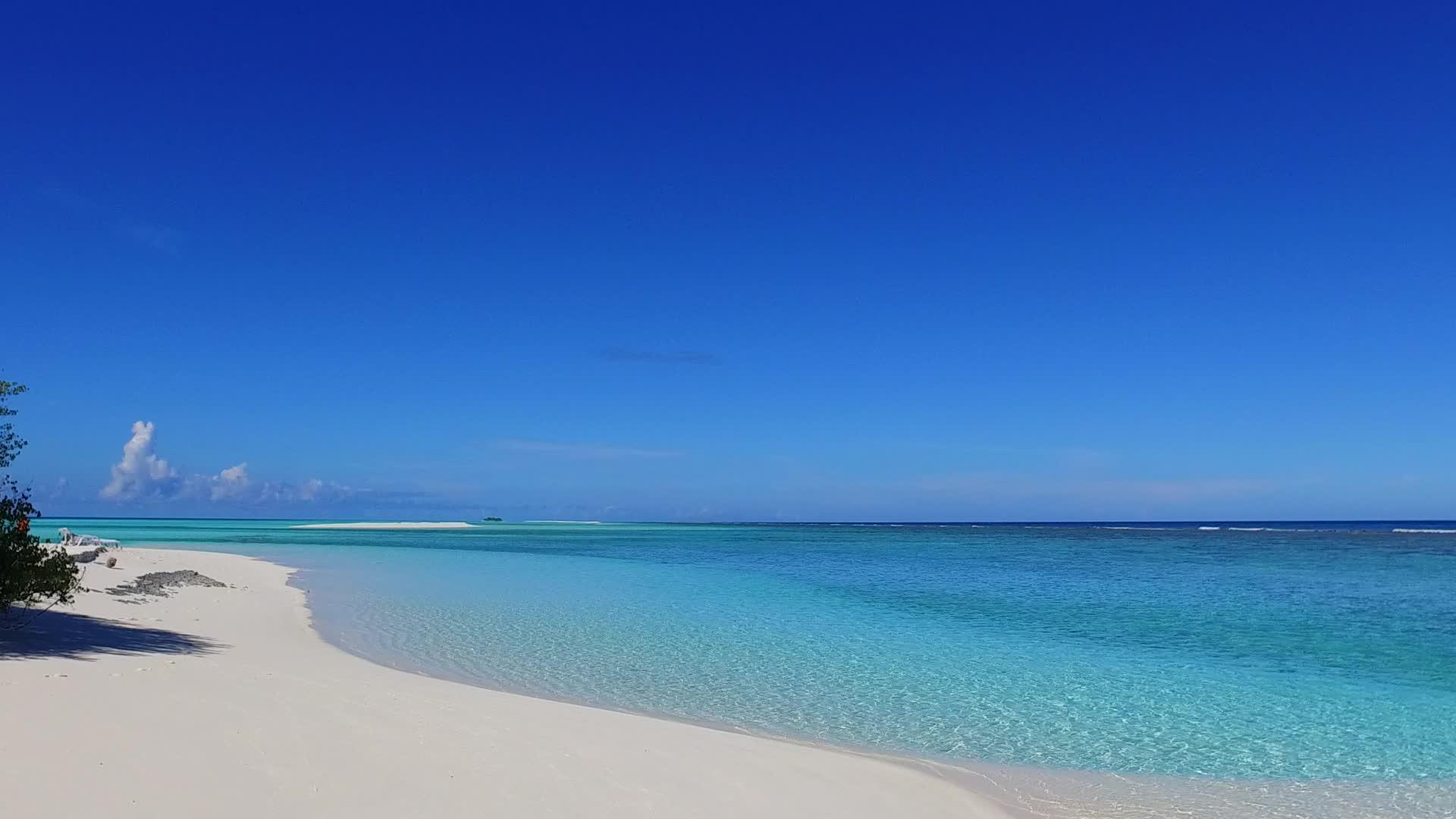 在蓝绿环礁湖和海滩附近的白沙底背景下放松海岸海滩度假视频的预览图
