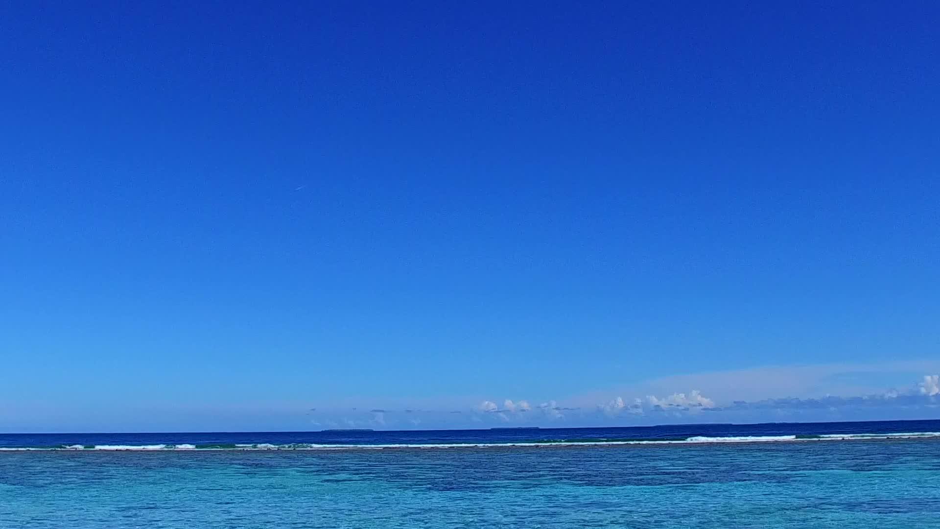 宽度海滩海滩通过波浪附近透明的水和白色沙滩背景进行视频的预览图