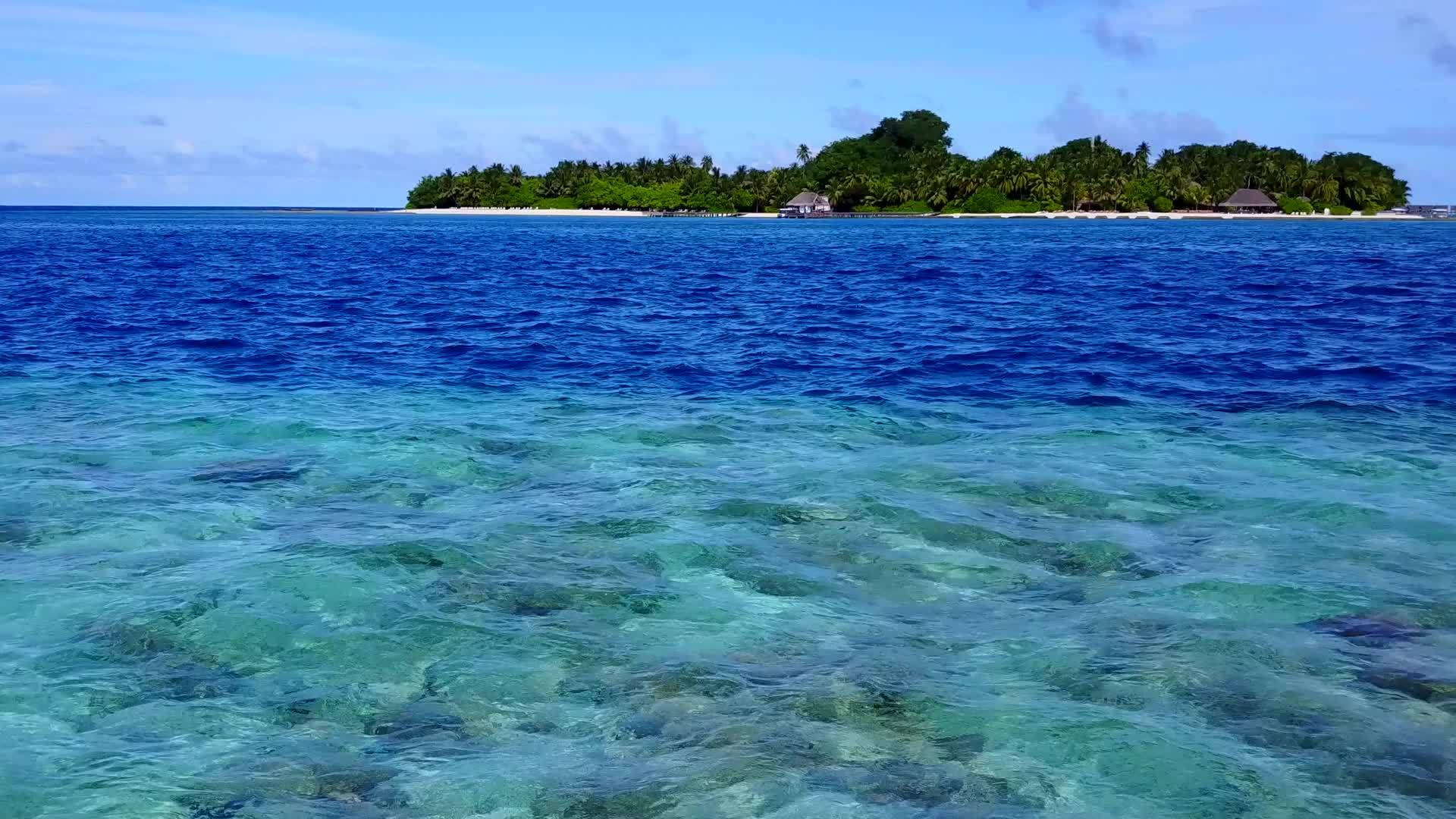 美丽的岛屿海滩被蓝色的海洋打破了太阳下有白色沙子的背景视频的预览图