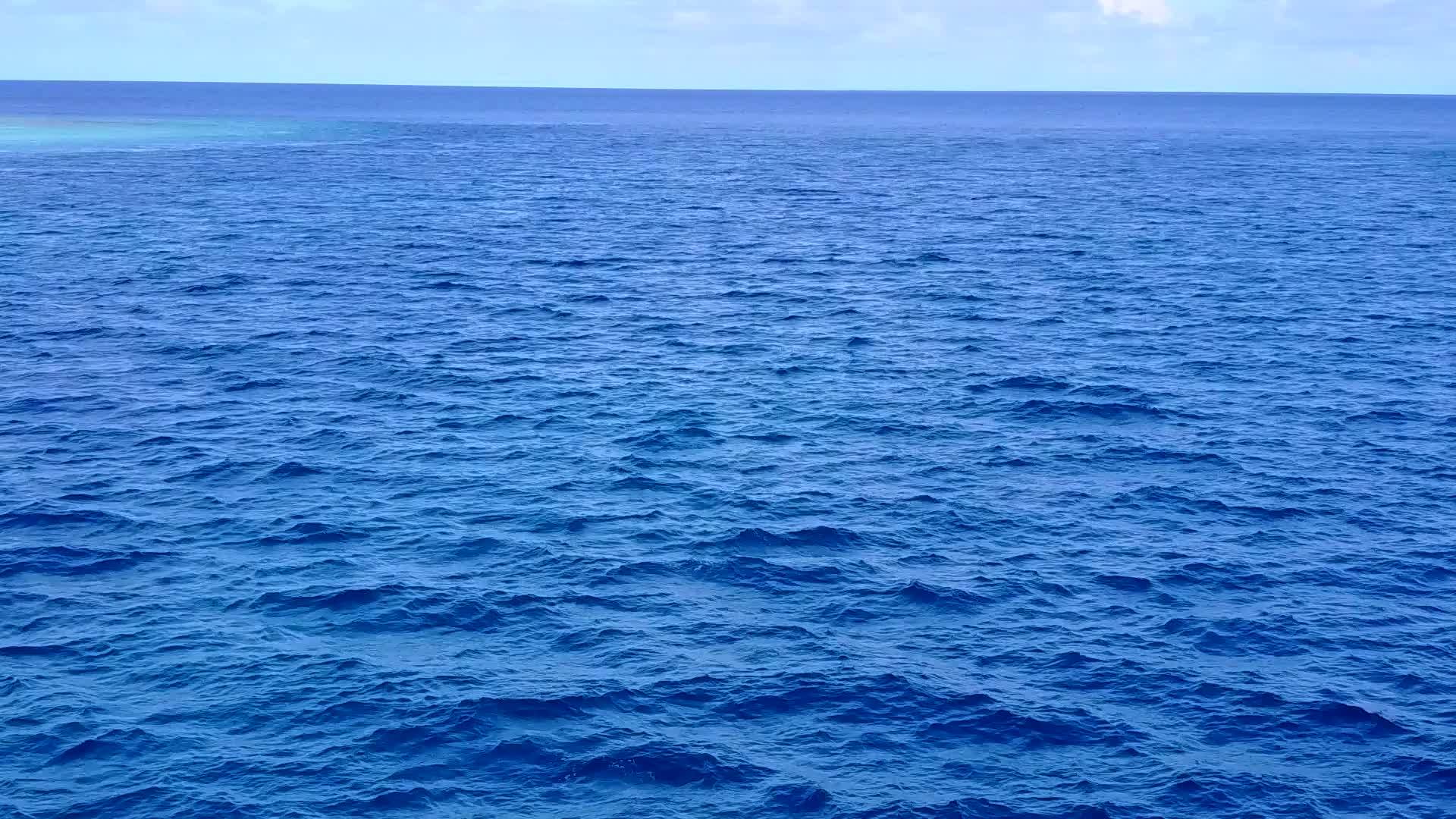 蓝色泻湖靠近波浪的白色沙滩背景放松海滩旅行视频的预览图