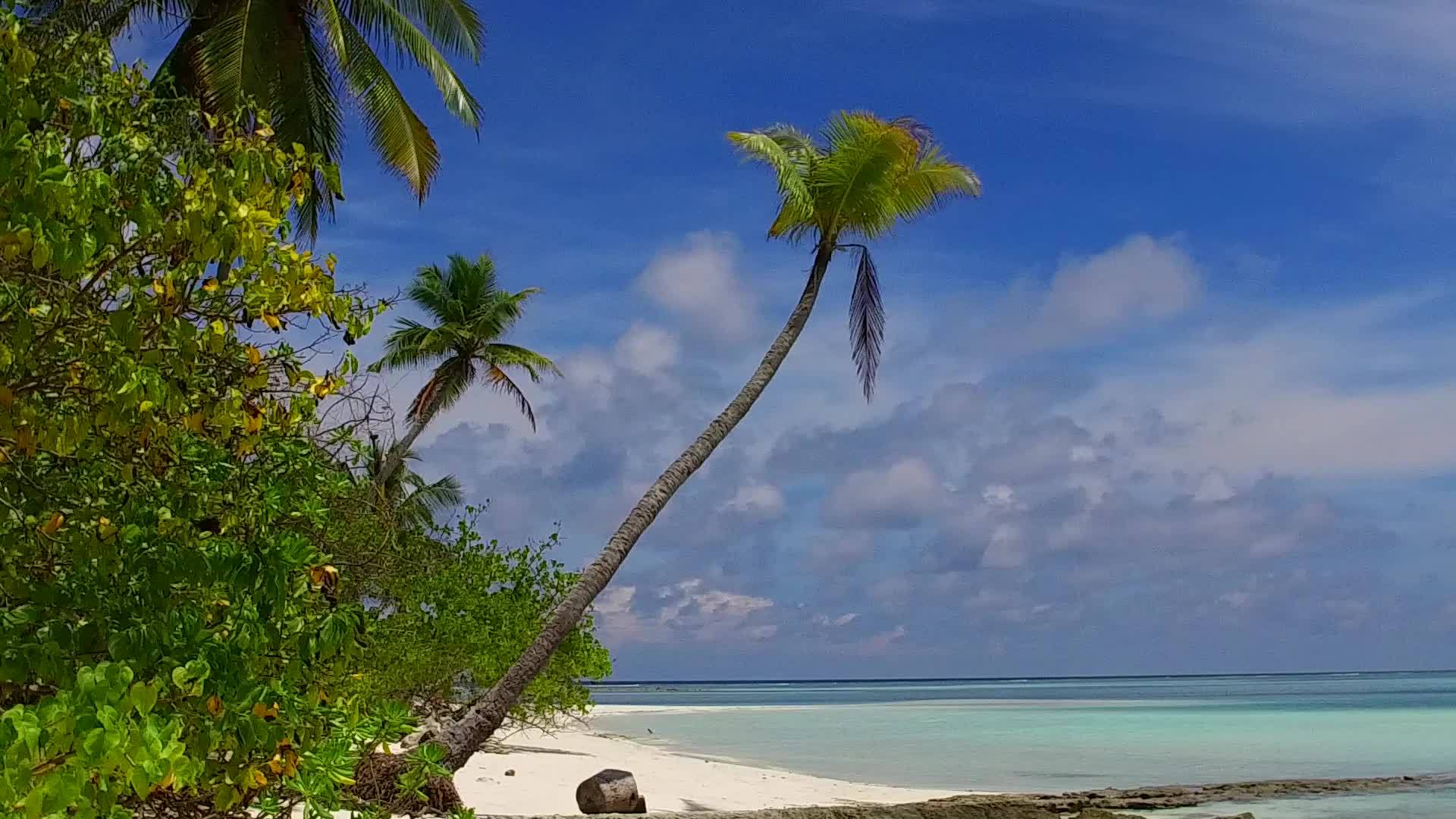 阳光明媚的环礁湖海滩天空伴随着蓝水和珊瑚礁视频的预览图