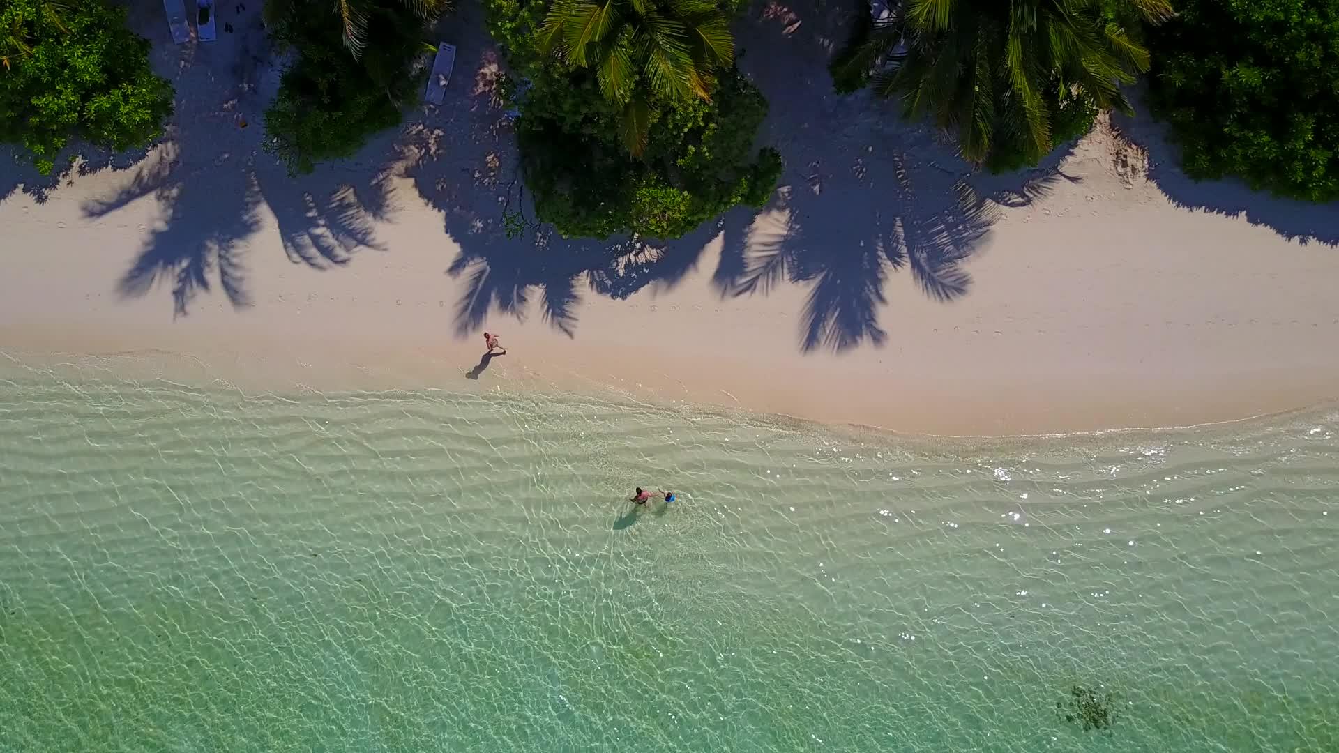 蓝色环礁湖的白色沙背景和冲浪附近的白色沙背景视频的预览图