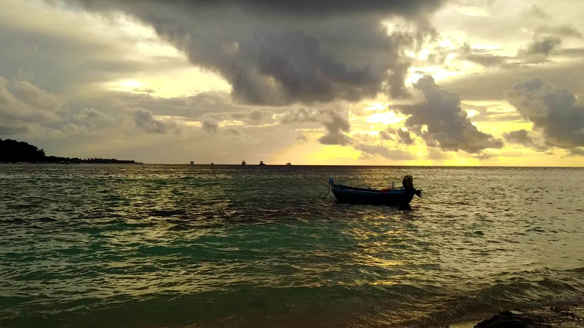 日落前干净的蓝水和豪华的海滩在沙地上航行视频的预览图