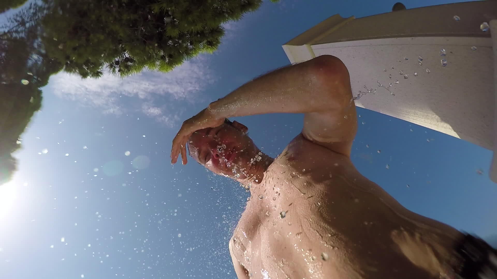在游泳池外洗澡的帅哥青年蓝天水滴入摄像头的第一个视角视频的预览图
