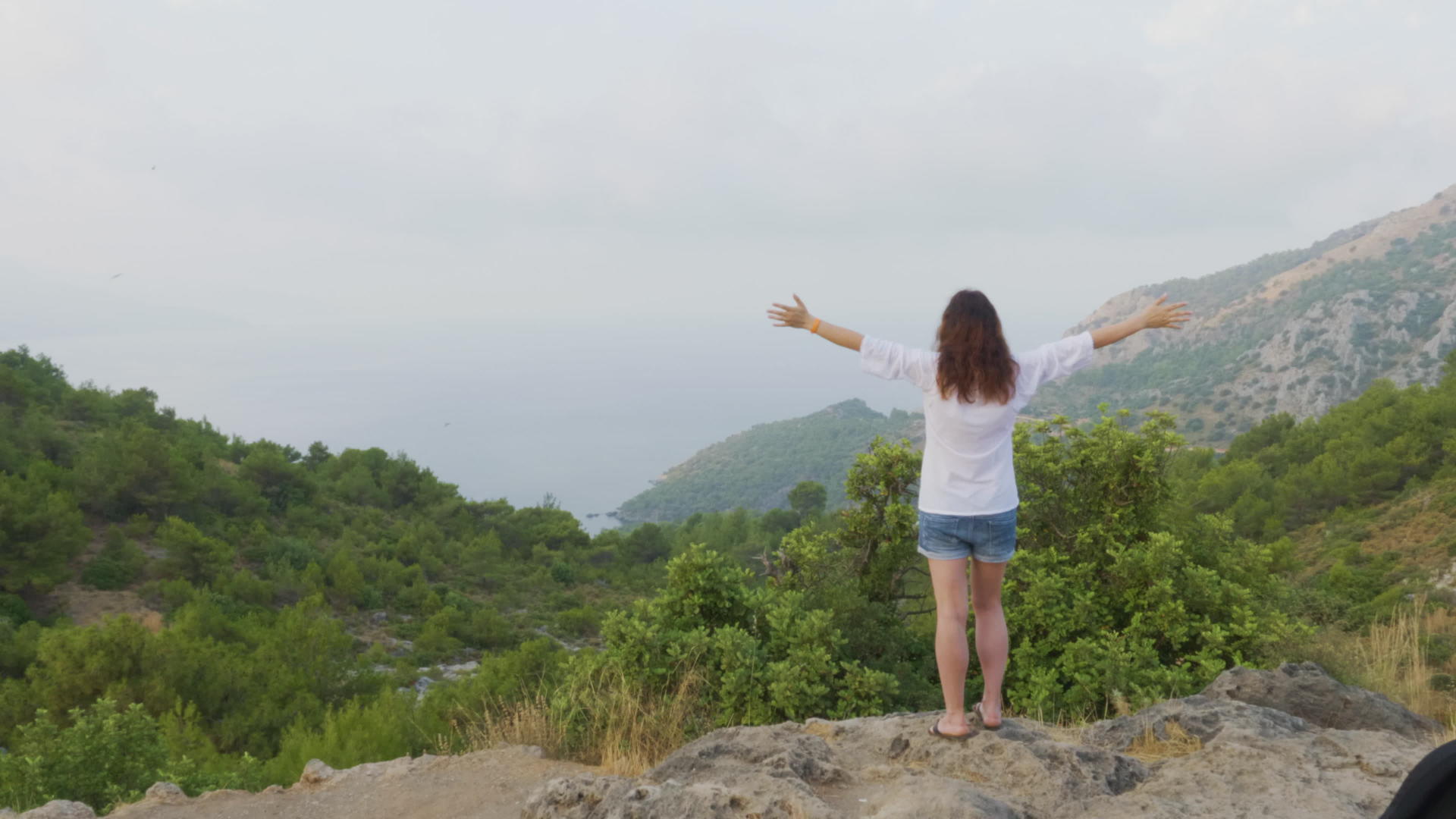 站在山边的旅游妇女伸出双手在青山景观中举手视频的预览图