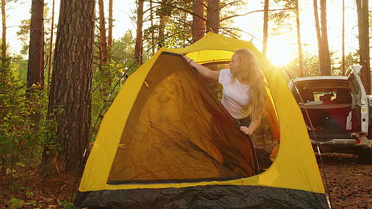 旅行女孩早上在森林的露营帐篷里醒来年轻女孩在旅游营地醒来视频的预览图