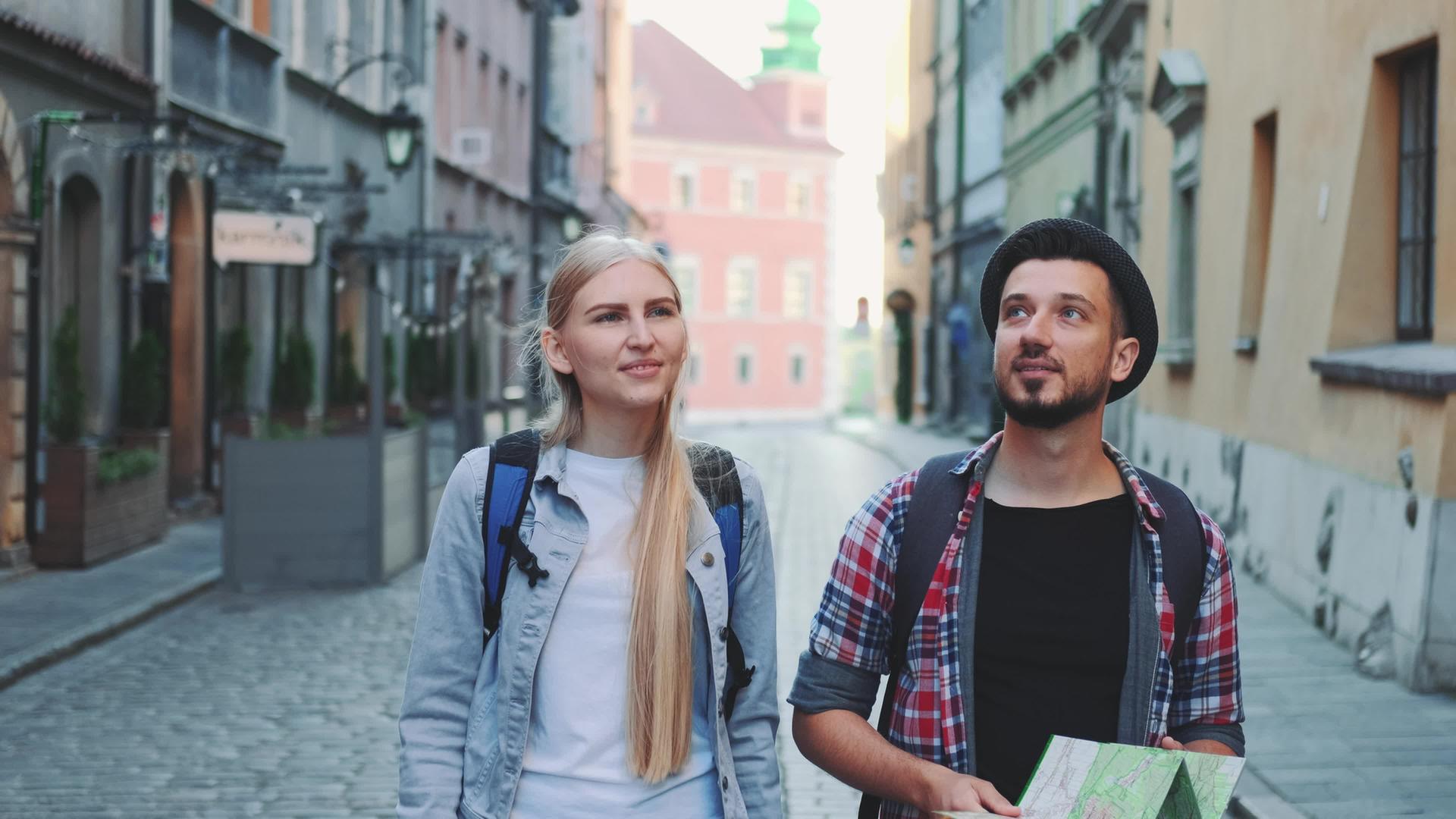 一对快乐的游客走在旧欧洲城市的中央街道上视频的预览图