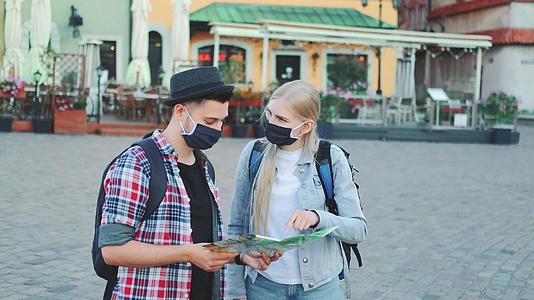 使用中市广场地图佩戴保护口罩的年轻游客视频的预览图