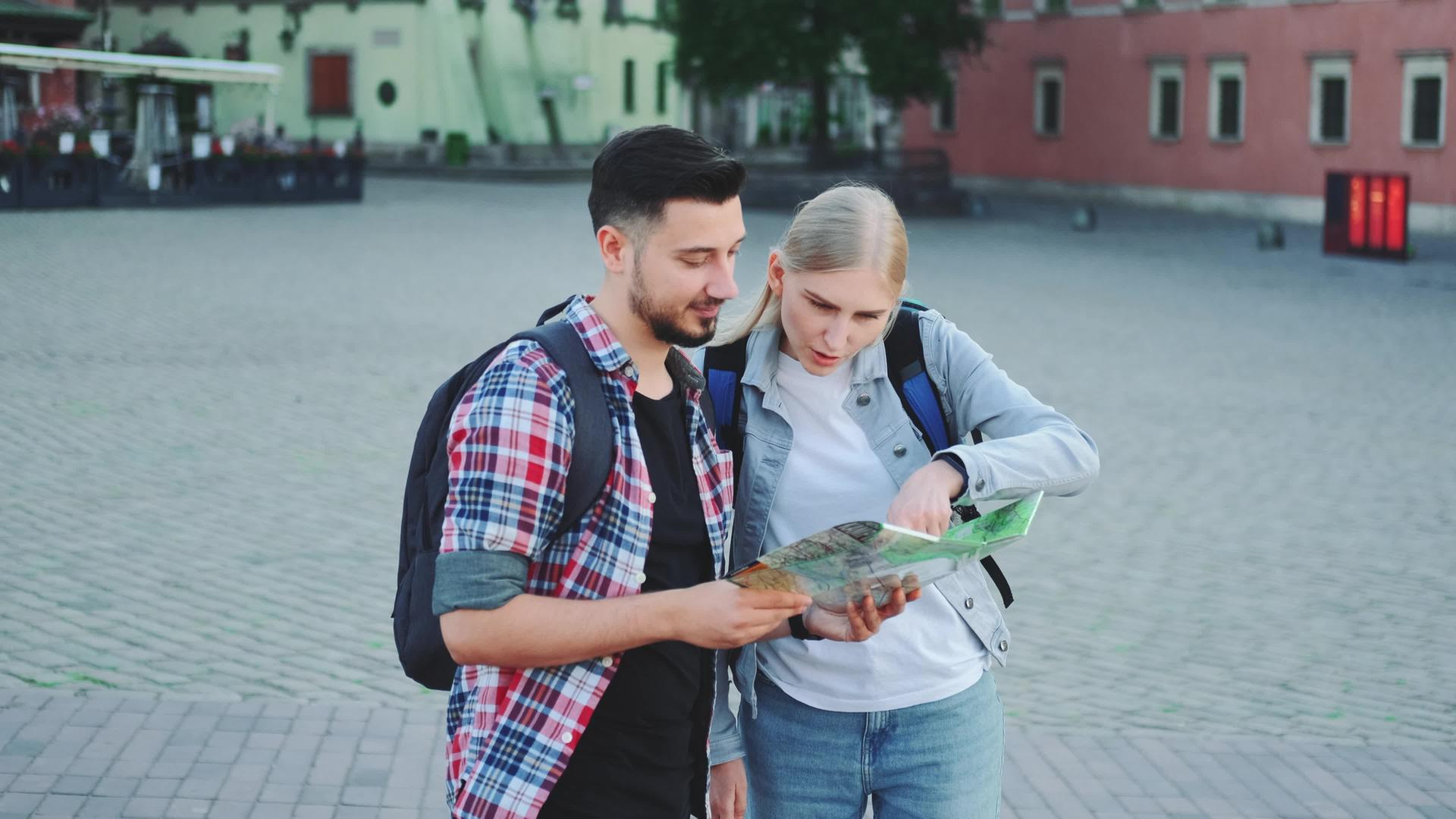 两位游客持有地图在城市广场寻找一个地方视频的预览图