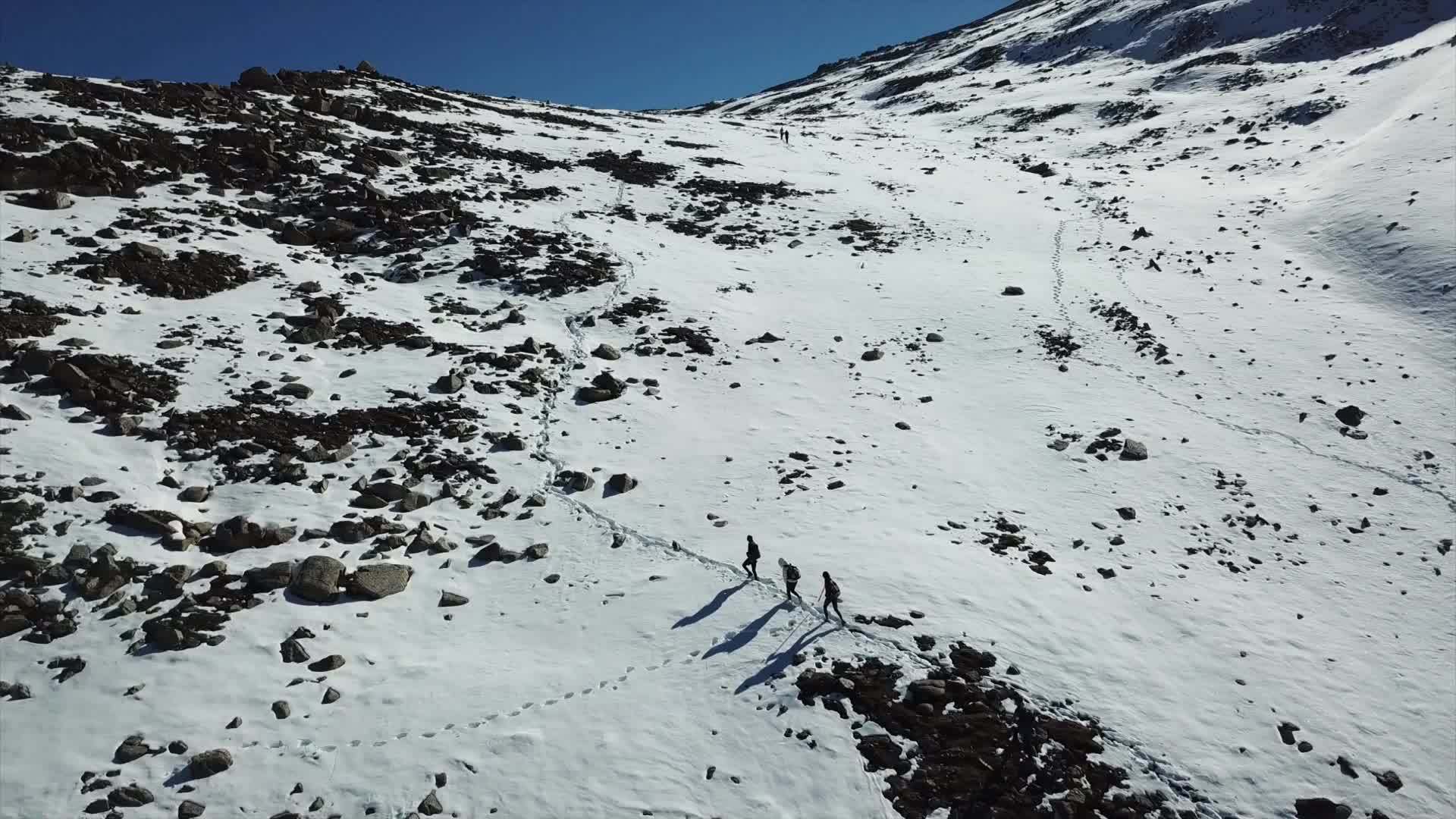 观光游客沿着山上的雪路行走视频的预览图